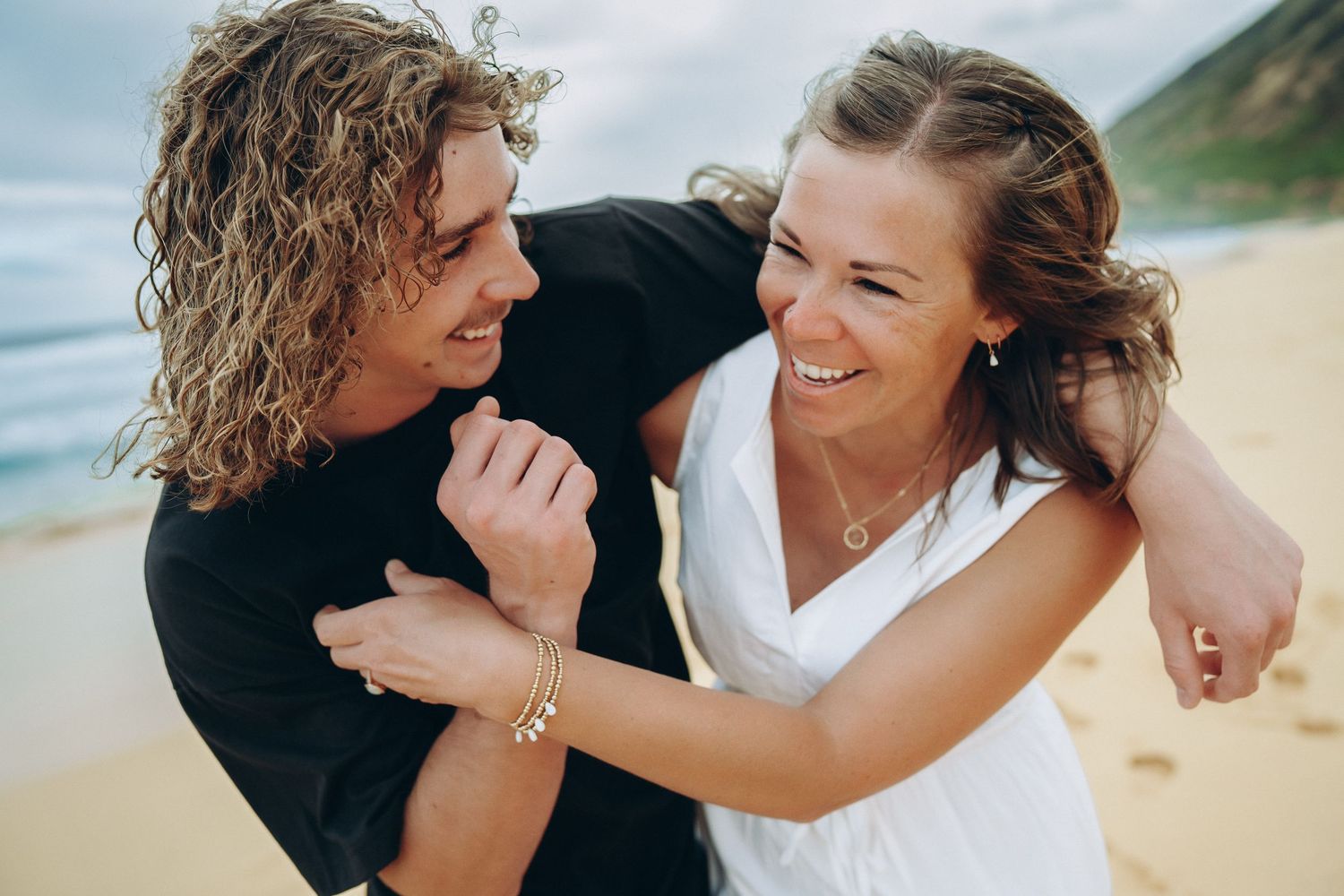 Mom and teenage son laughing in a warm hug on the sand, Sandy Beach Oahu family photographer, Hawaii