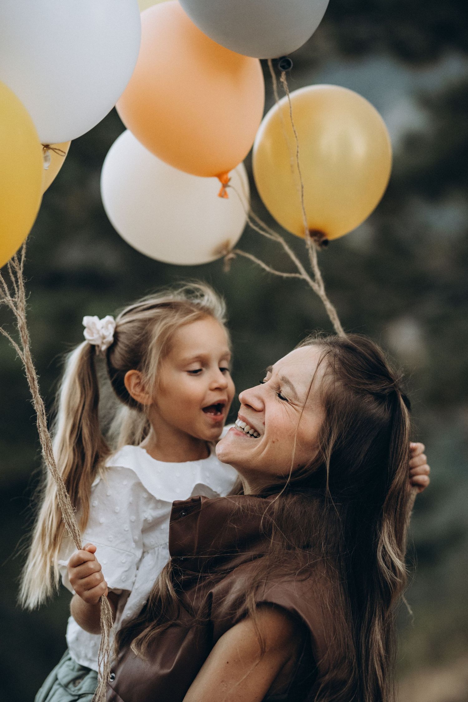 Mom hugging her daughter with balloons, Boulder family photographer, NCAR photo session in Colorado