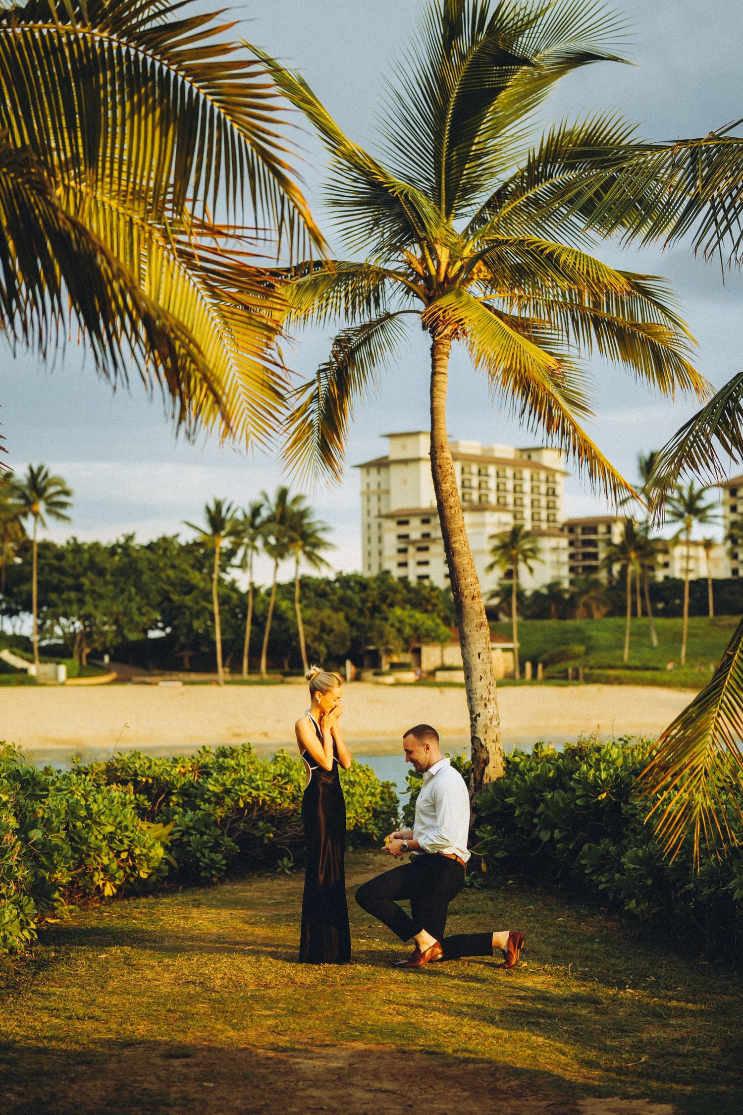 Romantic sunset proposal in Ko Olina. A young man asking his future bride to marry him on the beautiful shores of Oahu, Hawaii.