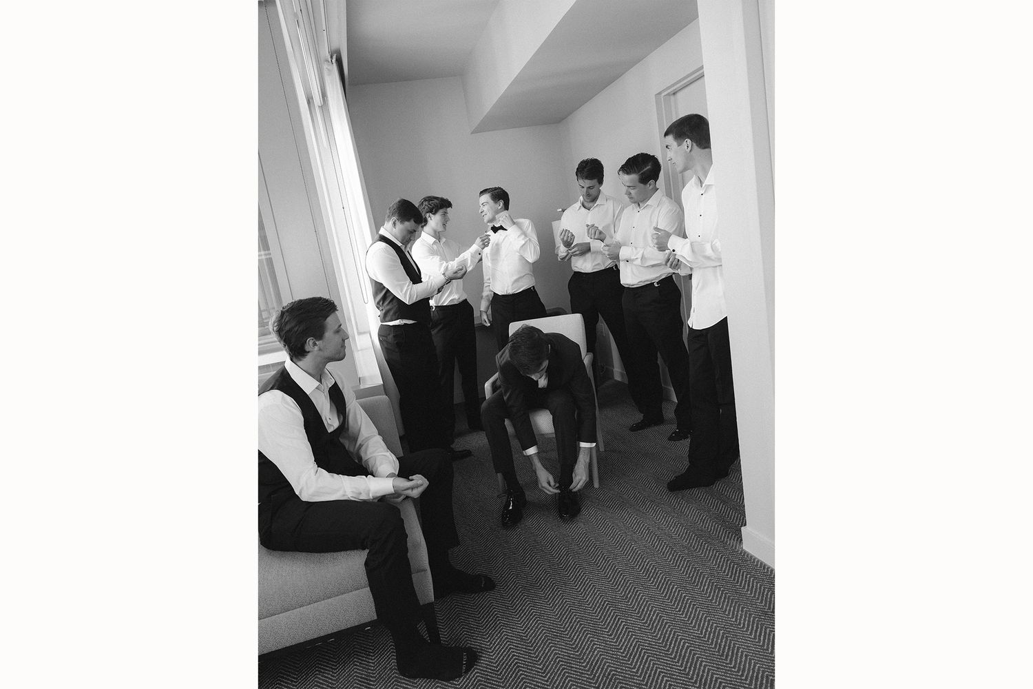 Medical professionals in white coats gather in a hallway for a discussion during rounds at a hospital.