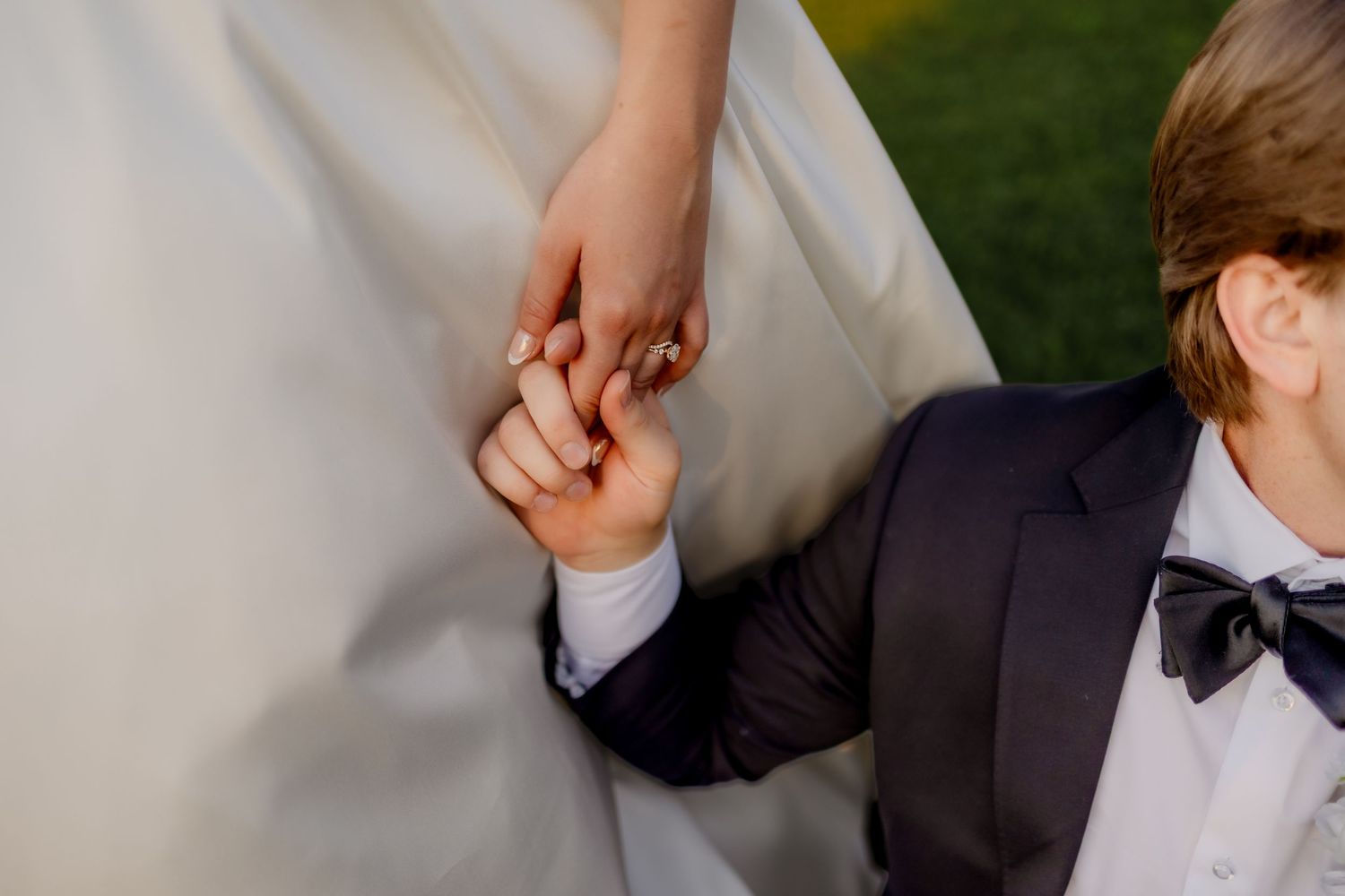 A wedding couple holds hands during their first dance at an elegant indoor wedding reception.