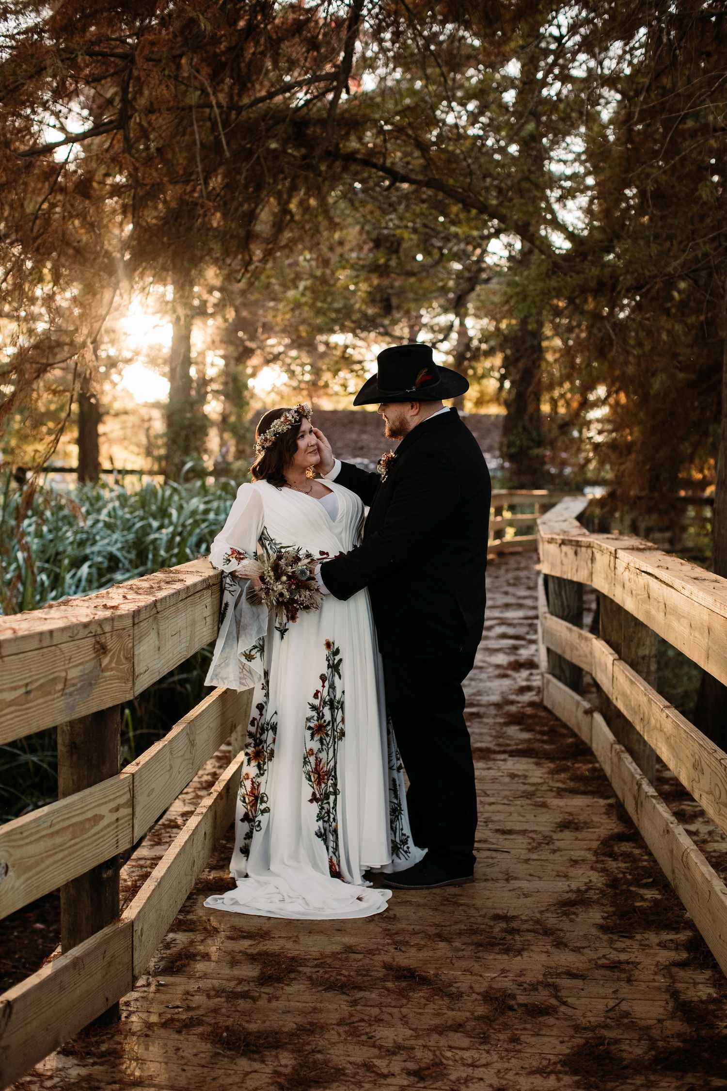 Couple in wedding attire embracing on a wooden bridge at sunset through a series of romantic shots.