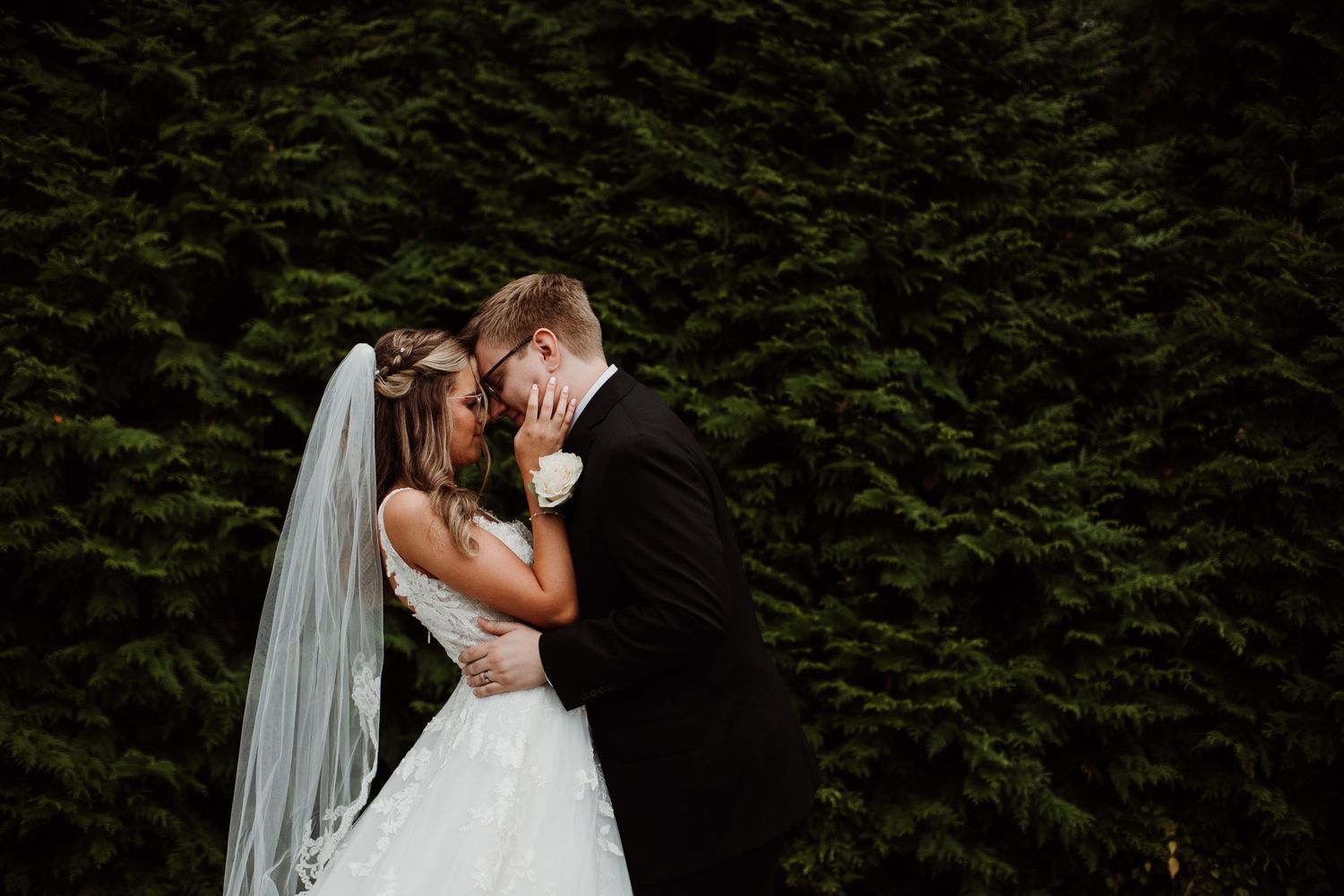 Romantic wedding couple sharing intimate kisses in multiple poses against a lush green garden backdrop.