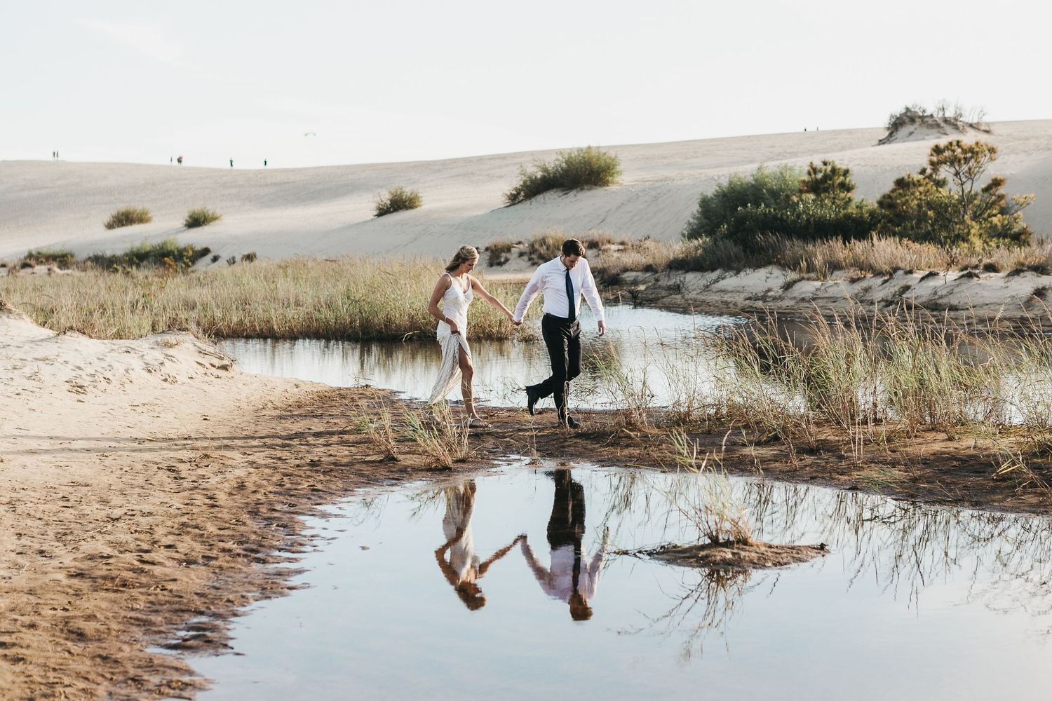 Scenic beach photography session with water reflections at sunset.