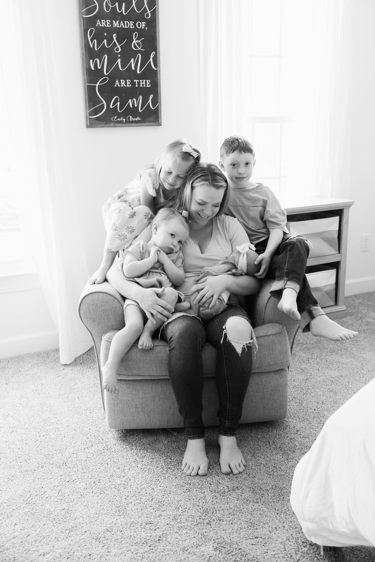 Family sharing tender moments together on a grey armchair.