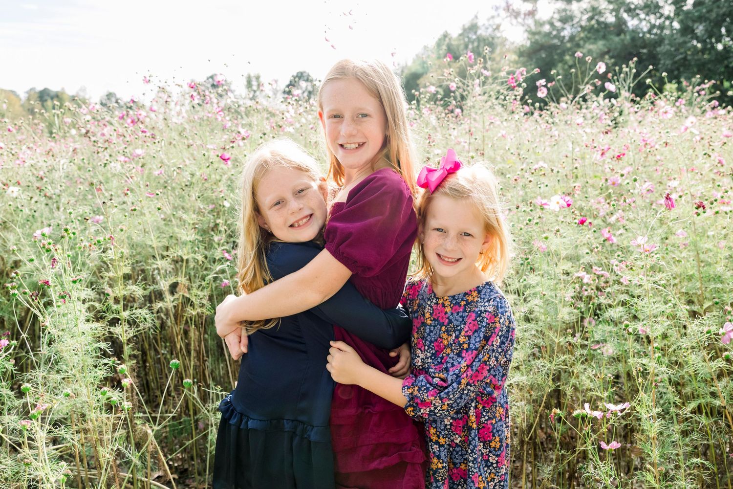 Children playing in a wildflower field with pink blooms during summer.