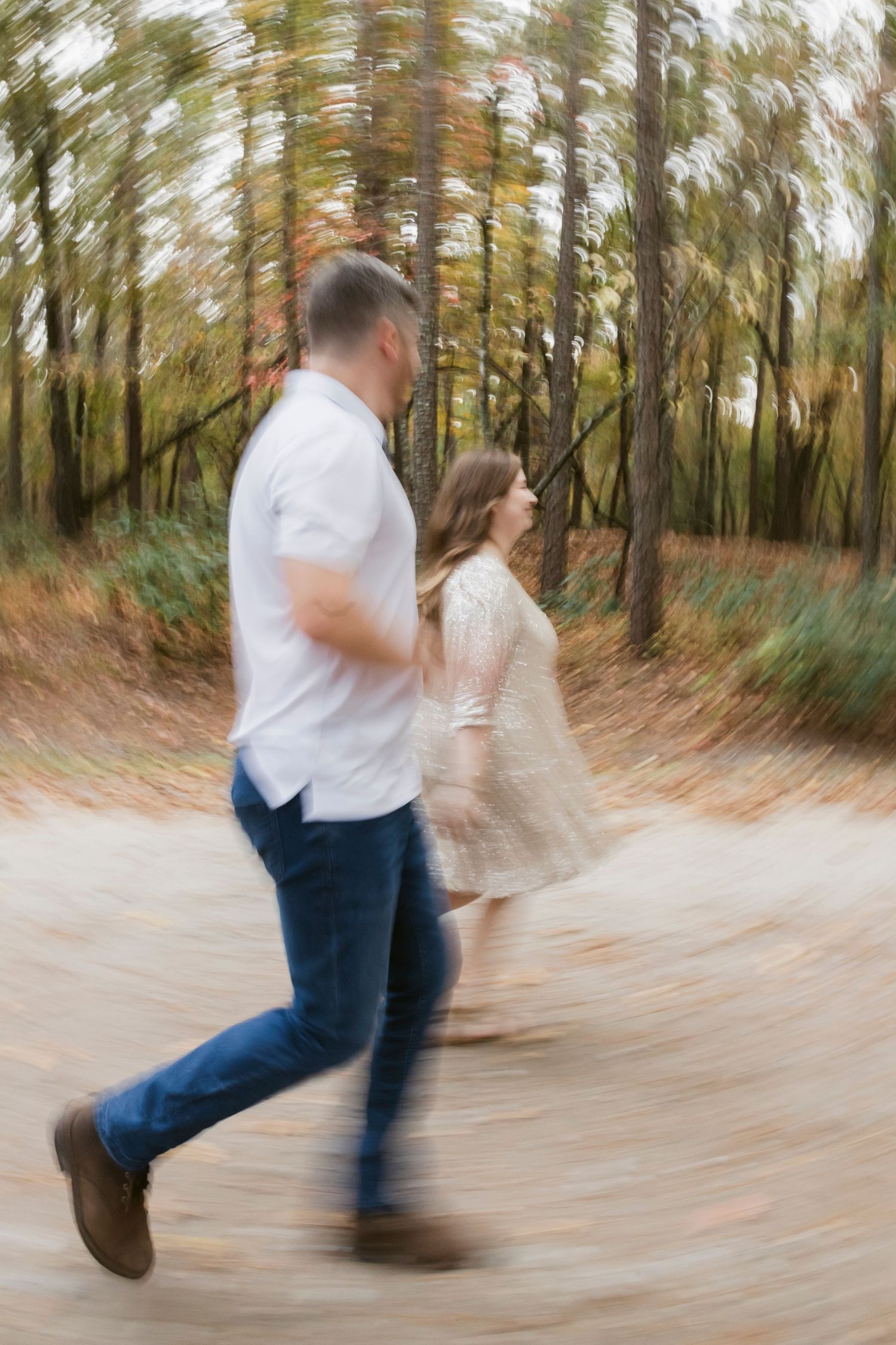 Motion-blurred sequence showing a couple dancing and spinning in an autumn forest.