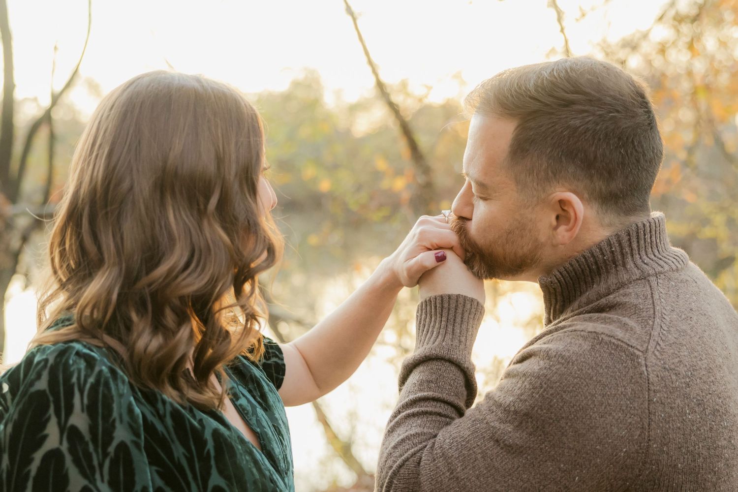 A couple shares an intimate moment during a fall photoshoot with golden leaves.