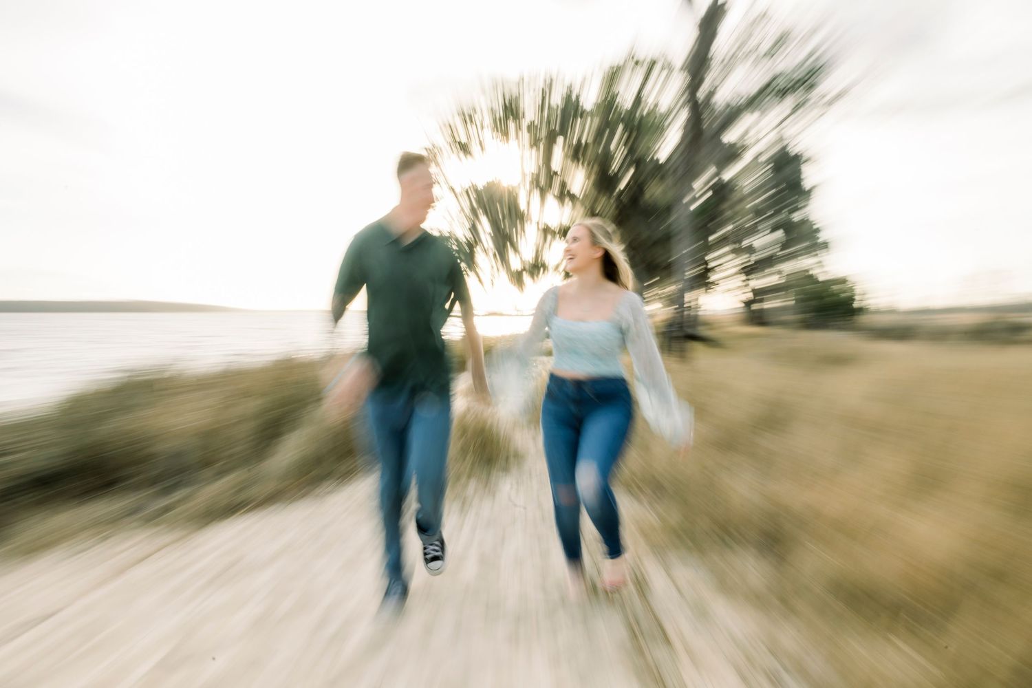 Motion-blurred sequence of a couple running and playing together in a sunlit outdoor setting.