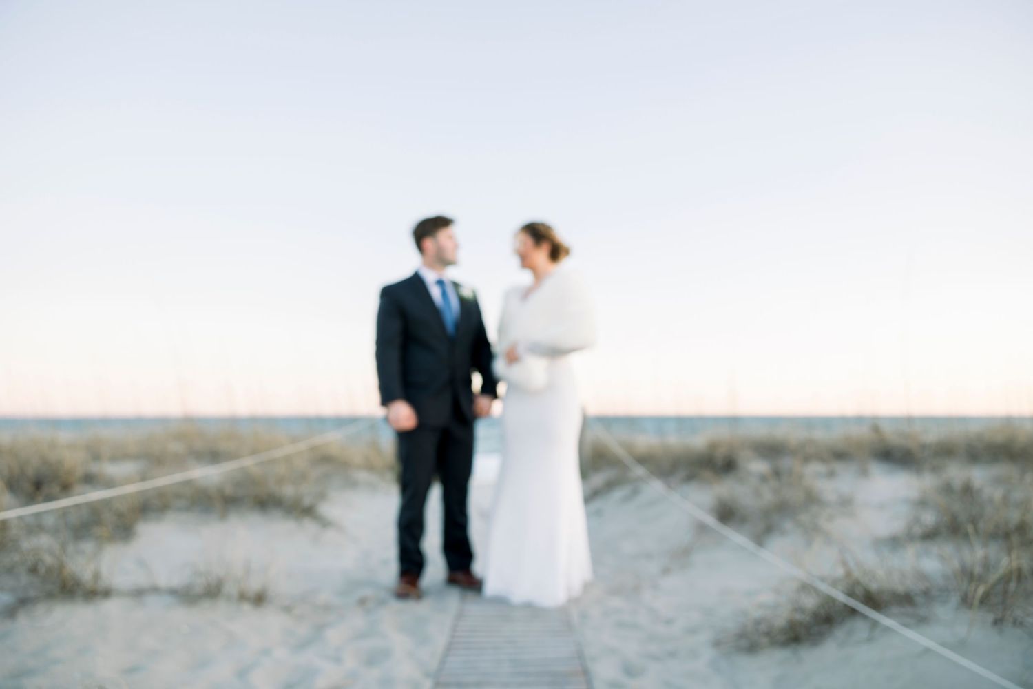 Wedding couple captured in romantic beach portraits with coastal scenery.