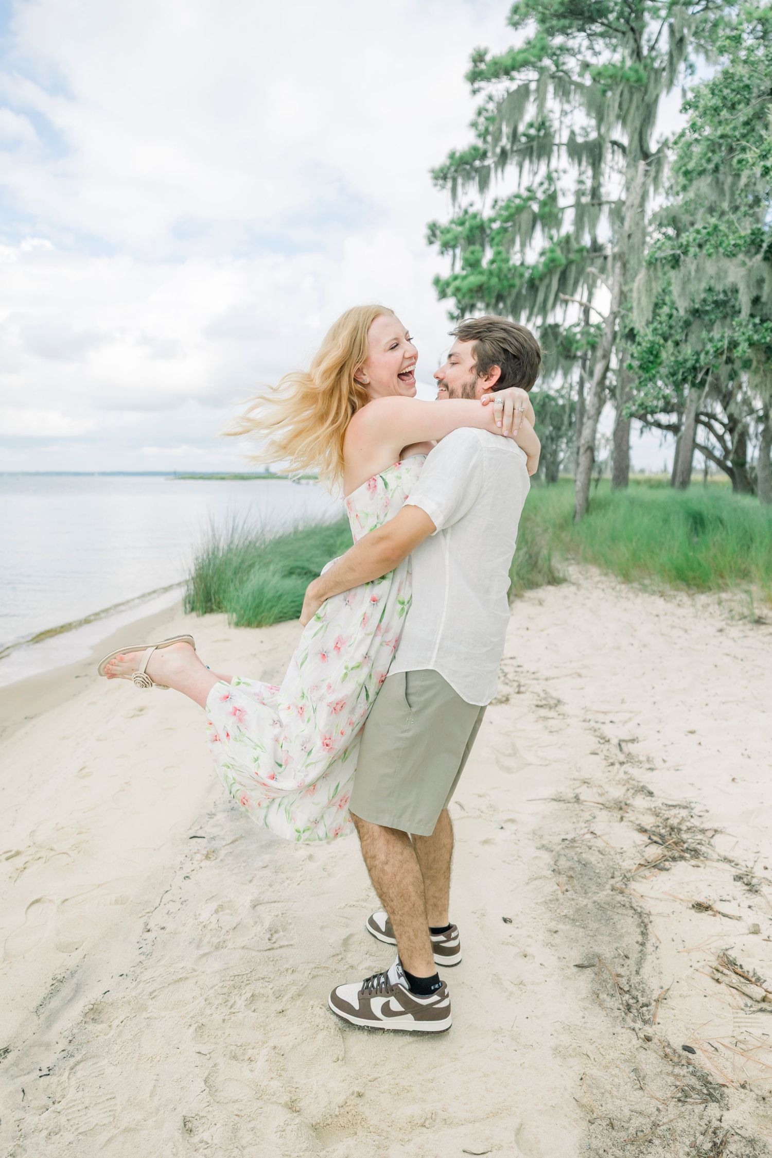 Playful beach photoshoot with Spanish moss trees and coastal scenery in the background.