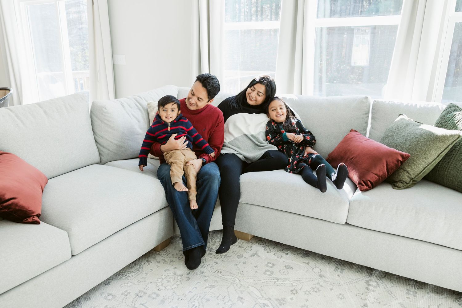 Casual lifestyle photos of a family relaxing on a white sectional sofa.