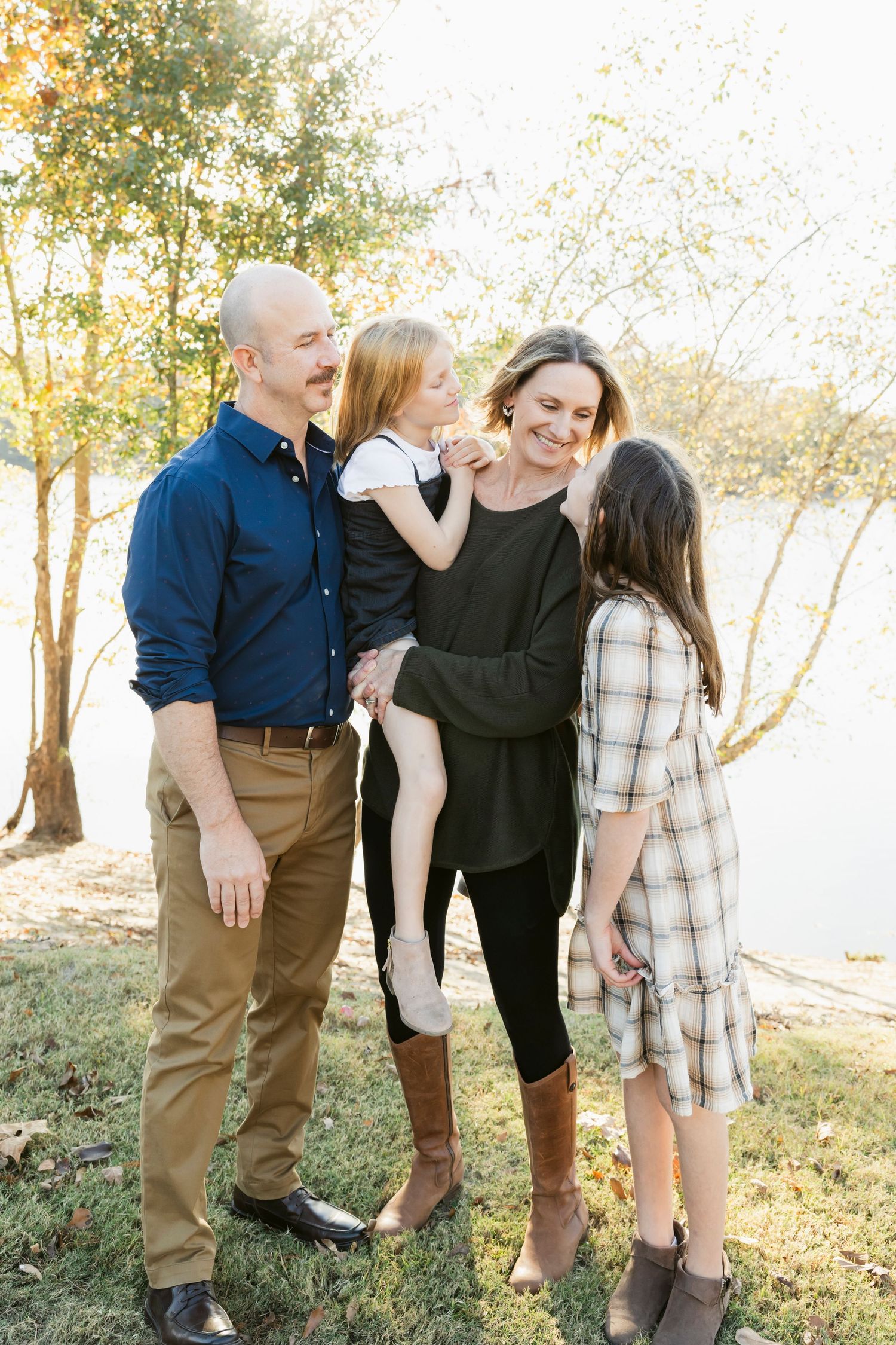 A family shares playful moments together in an outdoor setting during golden hour.