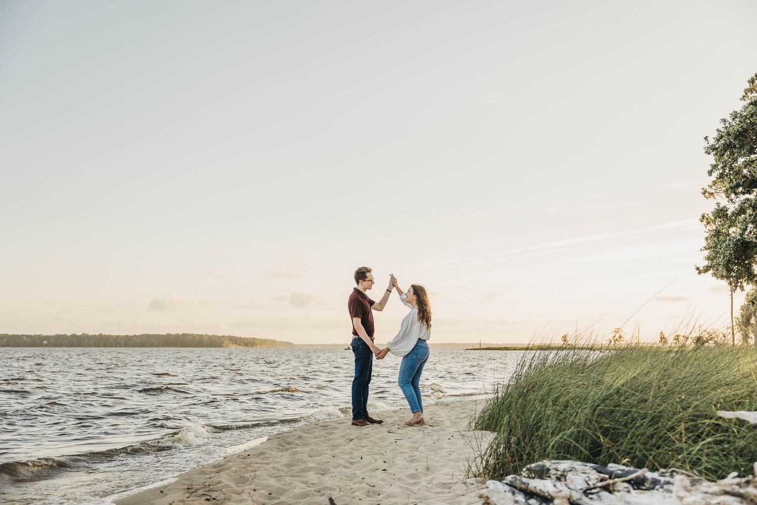 Coastal landscape photography with beach grass and water during golden hour.
