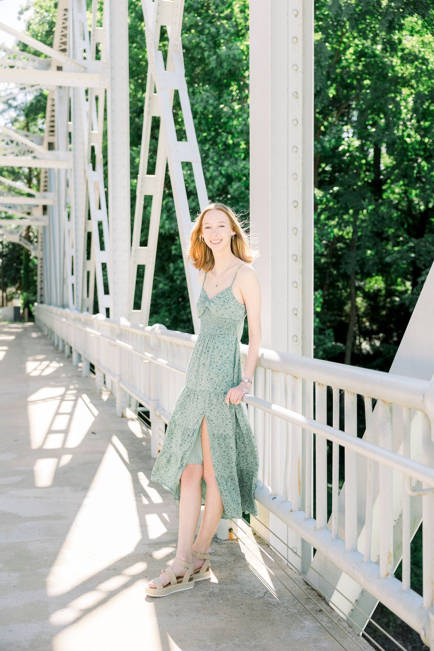 Elegant poses captured on a white architectural bridge with dramatic shadows and natural lighting.