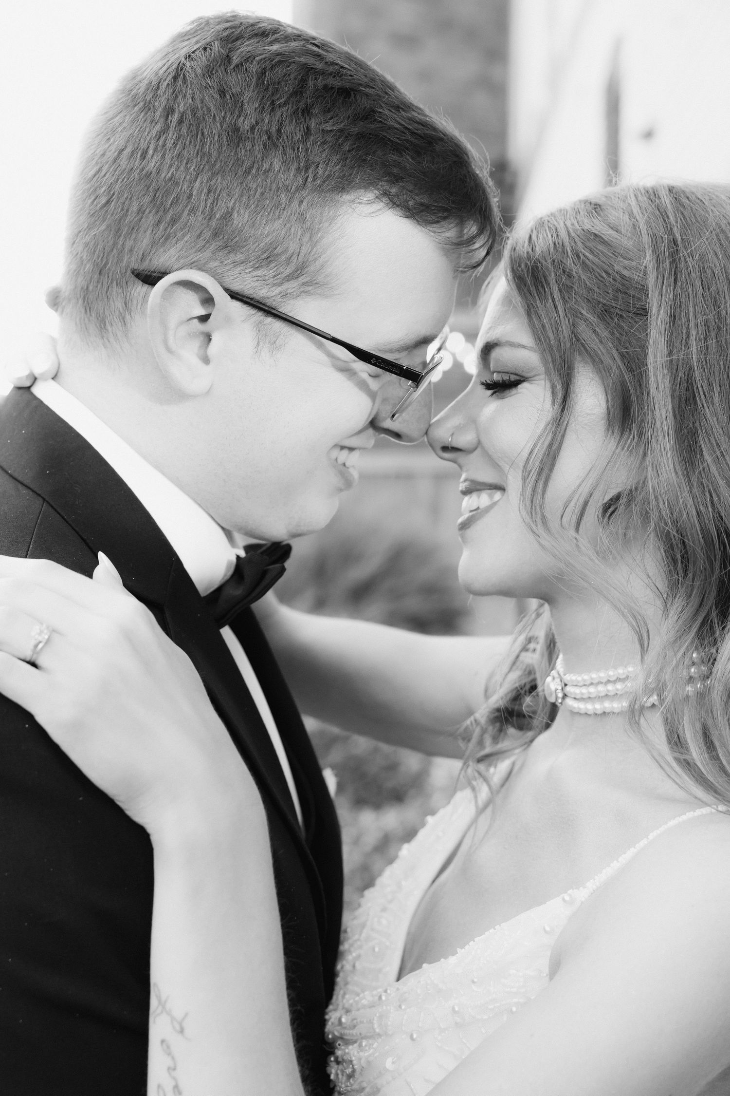 An intimate black and white portrait capturing a tender romantic moment.