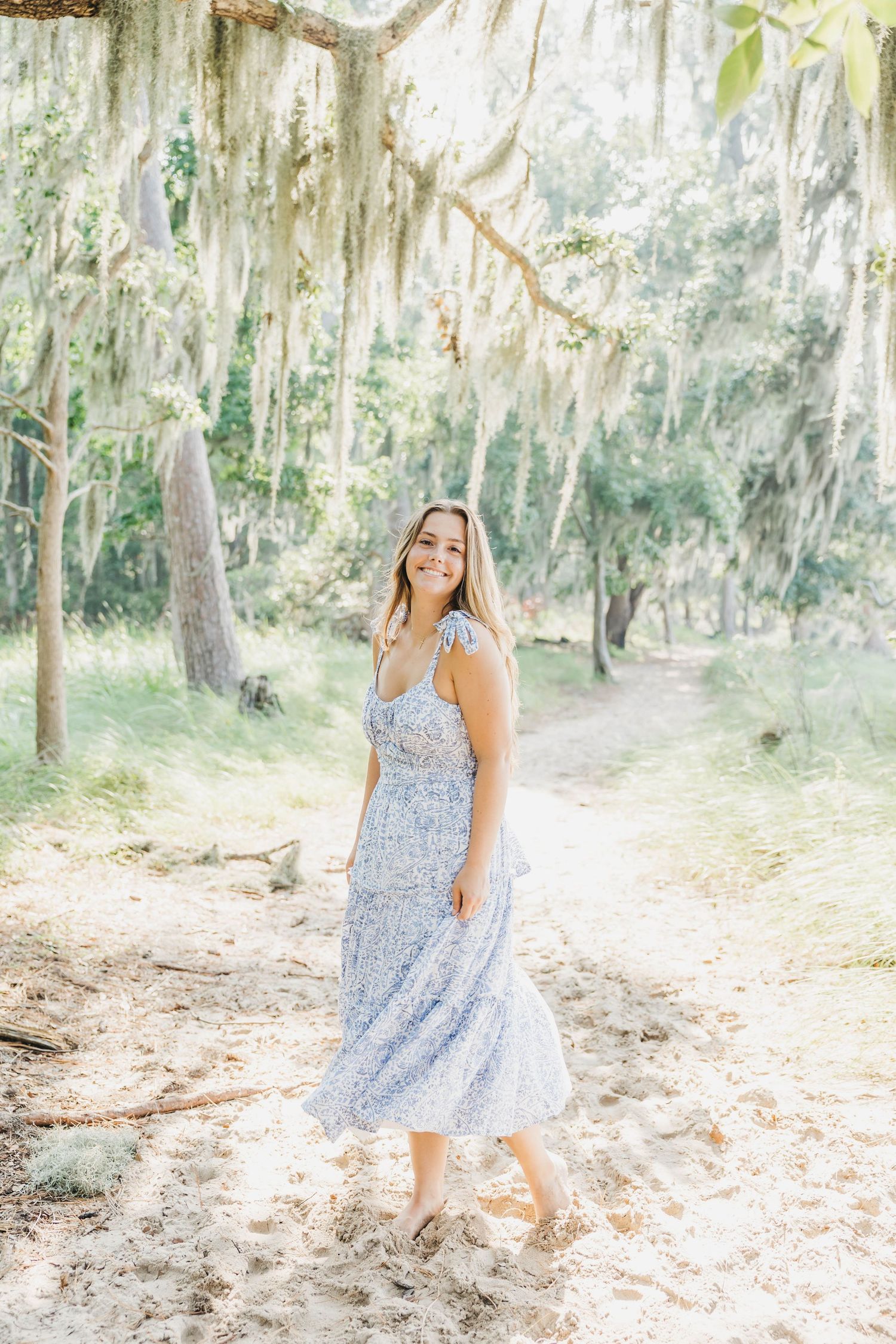 Summer photoshoot in a dreamy forest setting with Spanish moss and filtered sunlight.