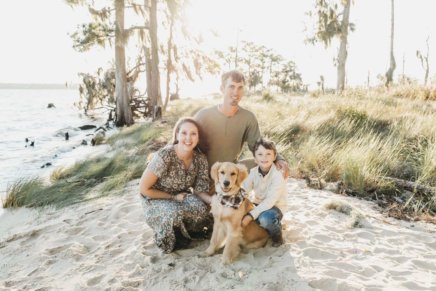 Family beach photos with golden retriever dog on sandy shore at sunset.