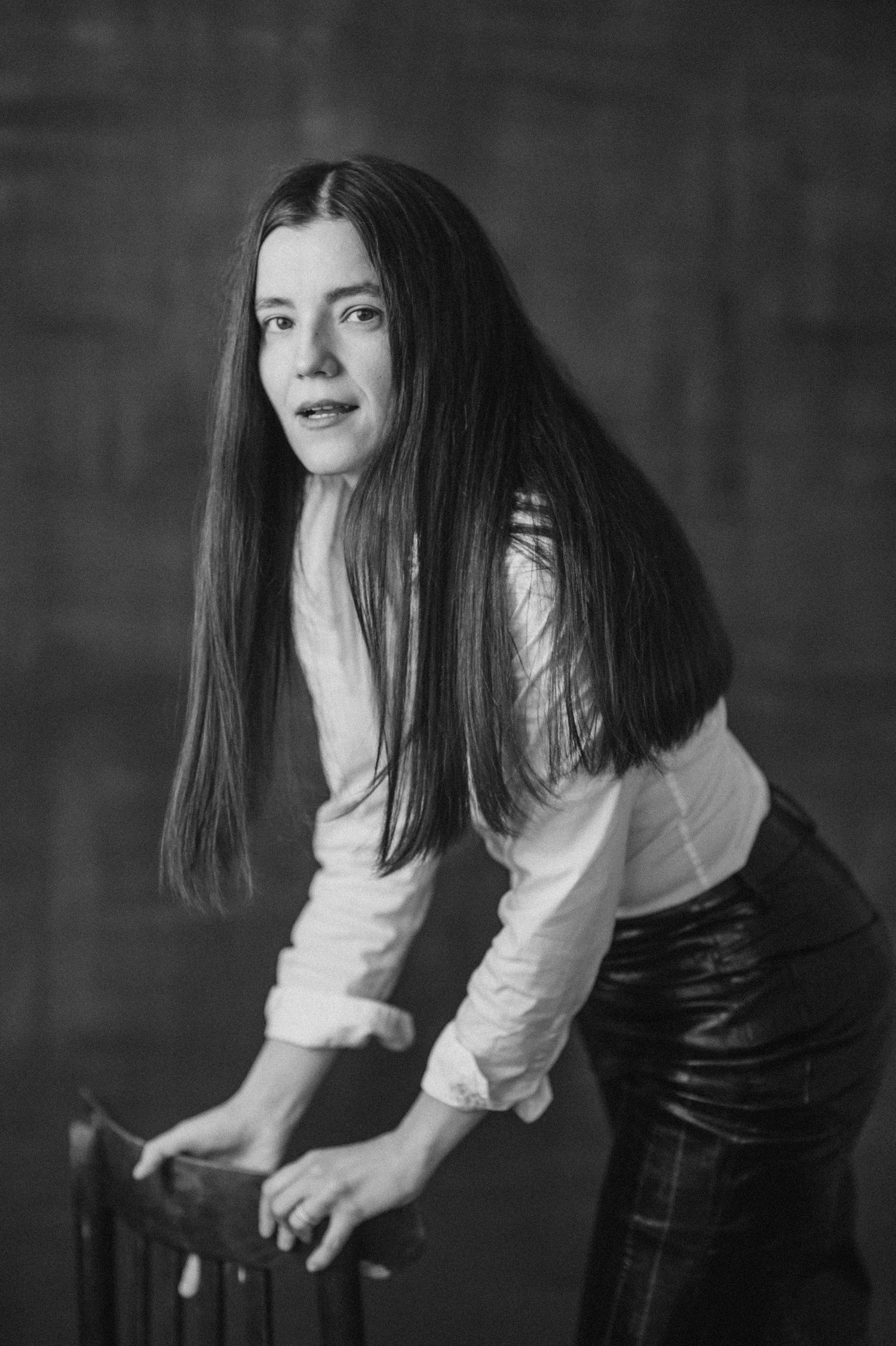 Black and white portrait series showing figure in white top and dark pants leaning forward in artistic poses.