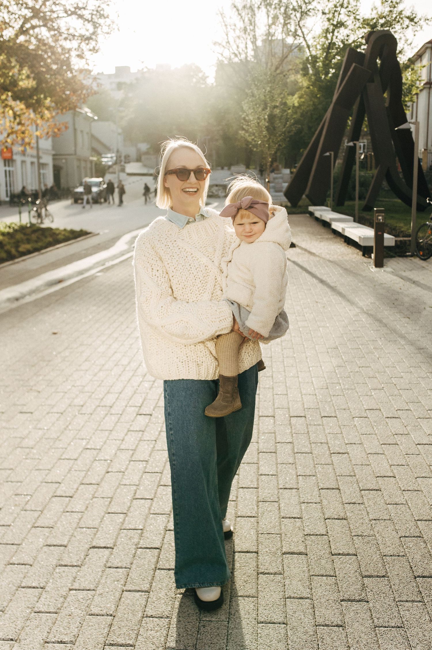 Candid lifestyle photos of family walking and playing together on a sunlit brick pathway.