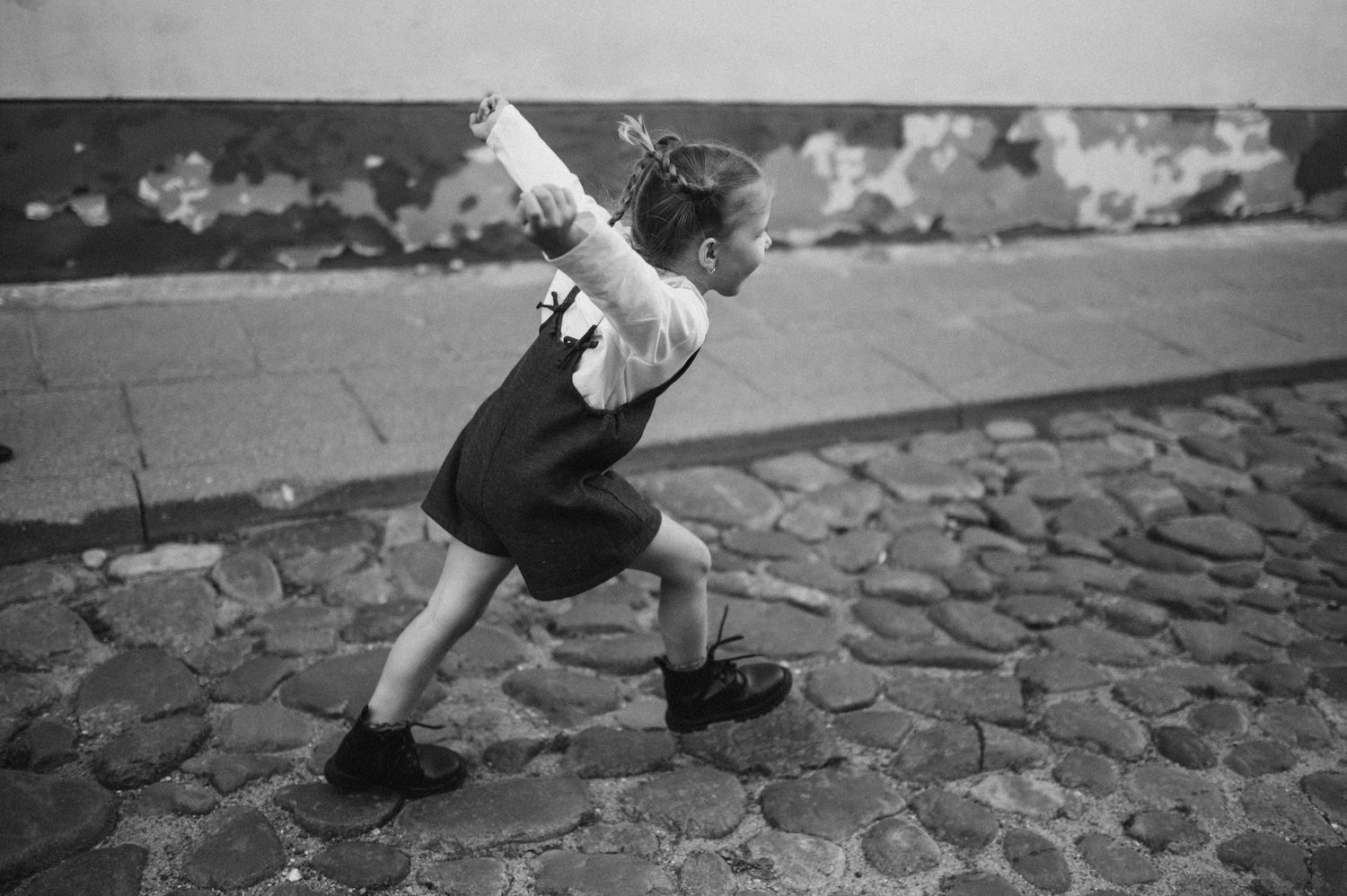 Low angle view of feet walking on cobblestone pavement during a photoshoot.
