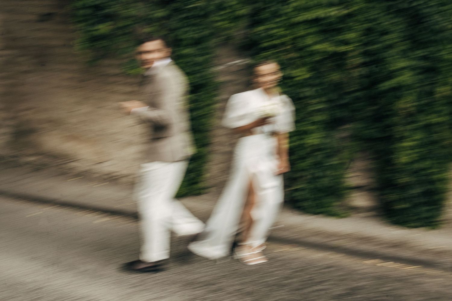 Motion-blurred artistic shot of a couple walking on a street.