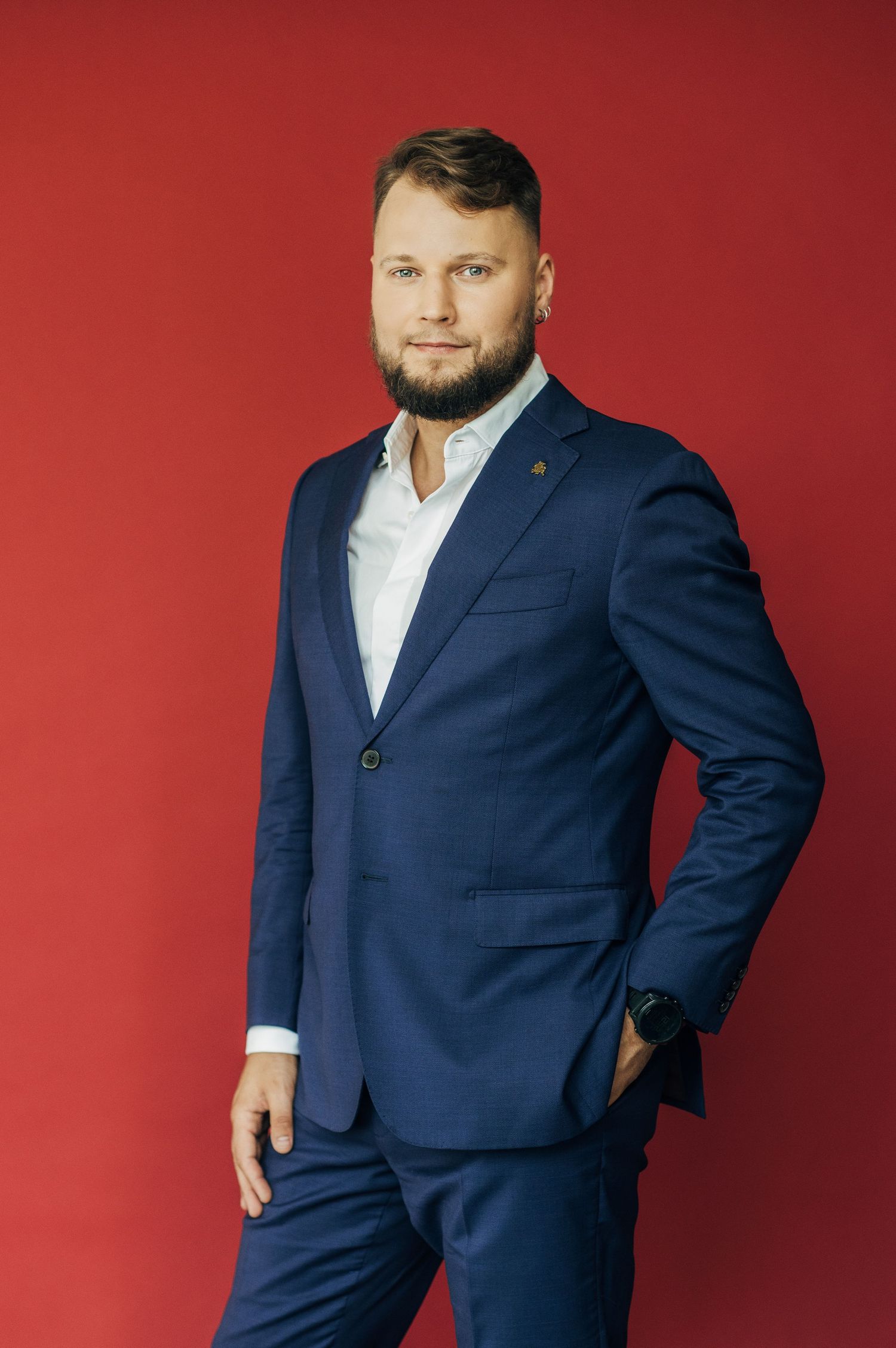 Professional portrait poses of a person in a navy suit against a red background.