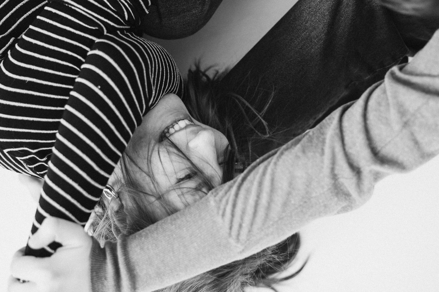 Black and white photos capturing intimate moments between people in striped and solid tops.