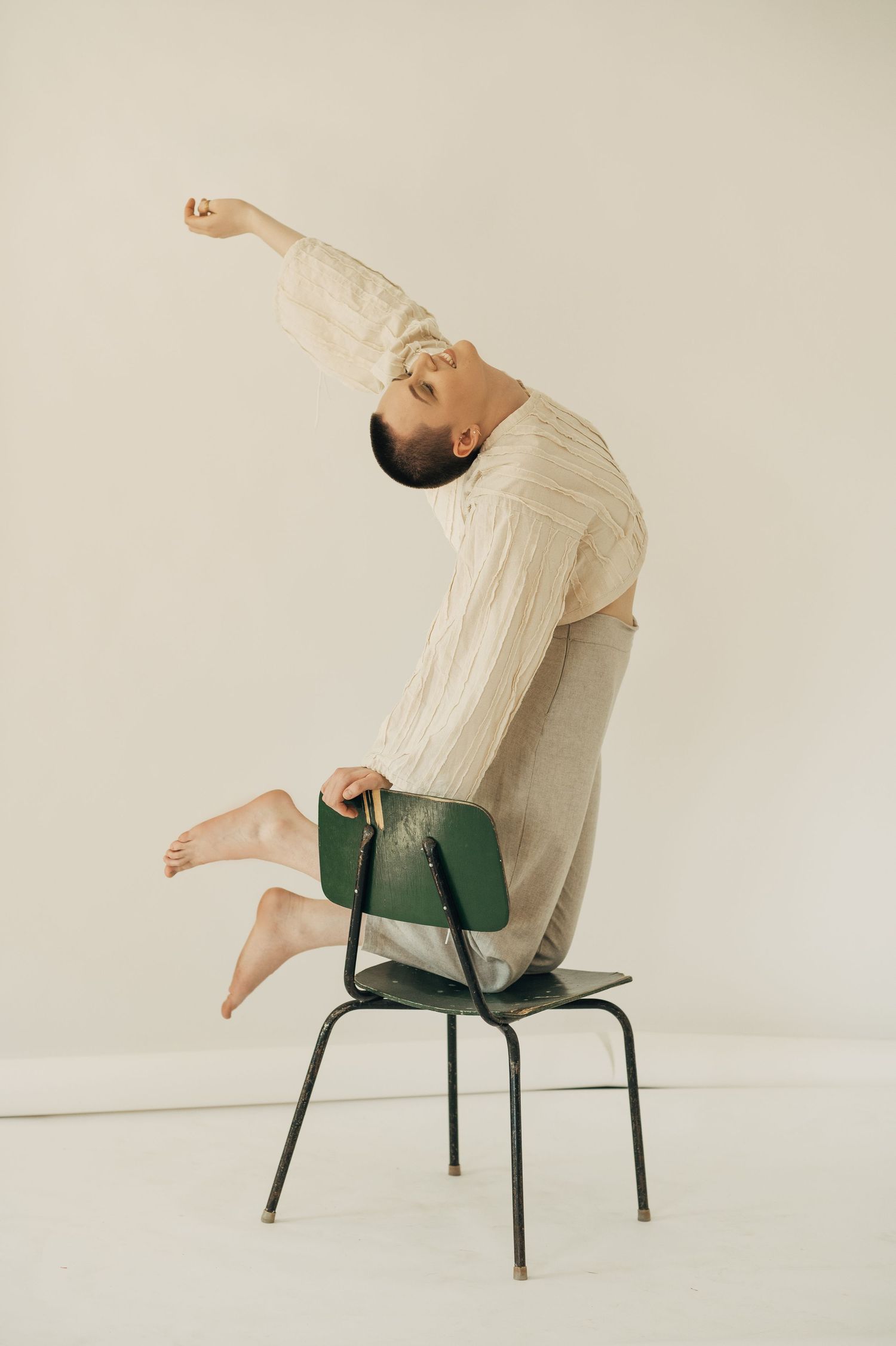 Artistic portrait series showing movement and poses on a simple chair against white background.