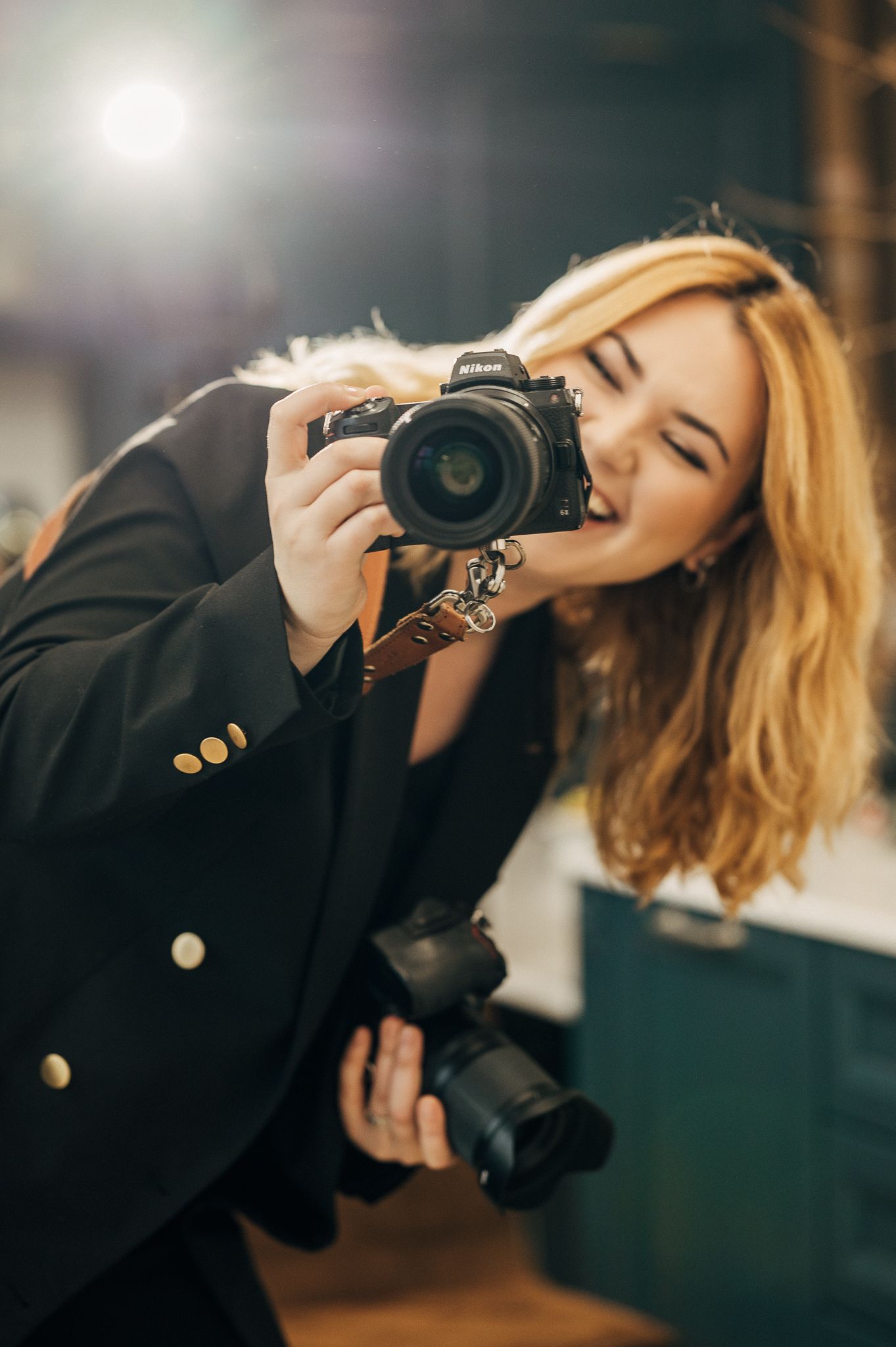 Stylish photographer with blonde hair drinks coffee while holding a professional camera in multiple artistic poses.