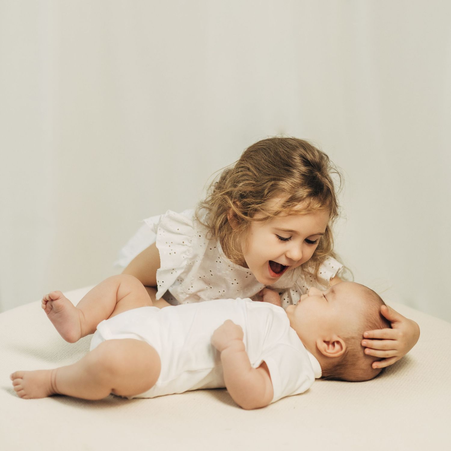 Series of artistic black and white photos showing a baby yawning and stretching on white background.