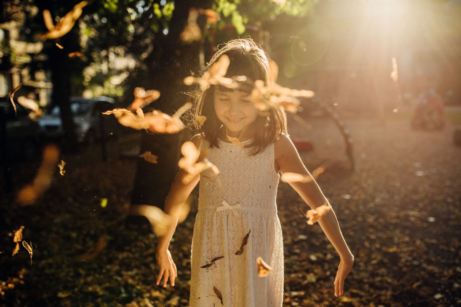 Silhouetted figures play and dance in golden sunlight creating magical autumn moments.