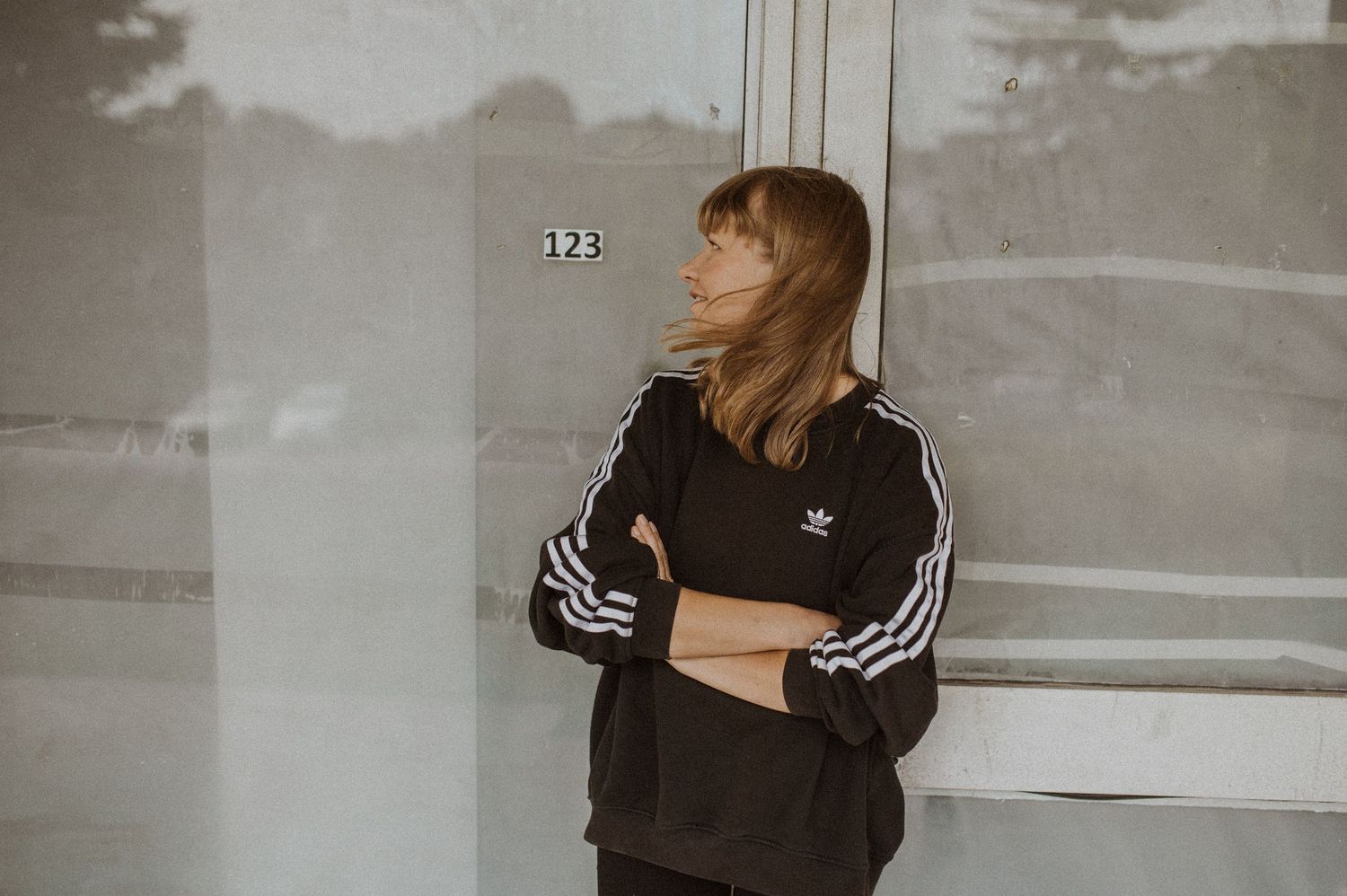 Person in black clothing moving through minimalist concrete space.