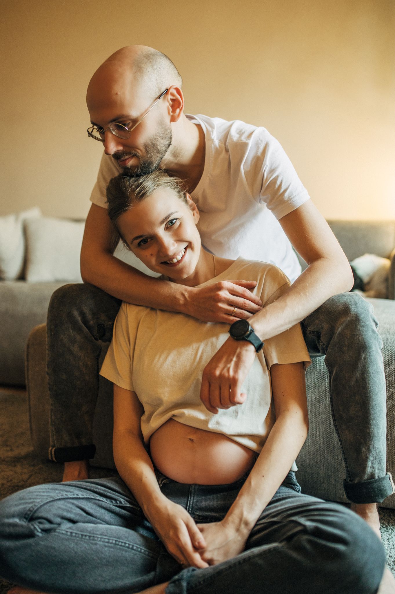 Tender moments captured in a series of photos showing affectionate interaction on a gray sofa.
