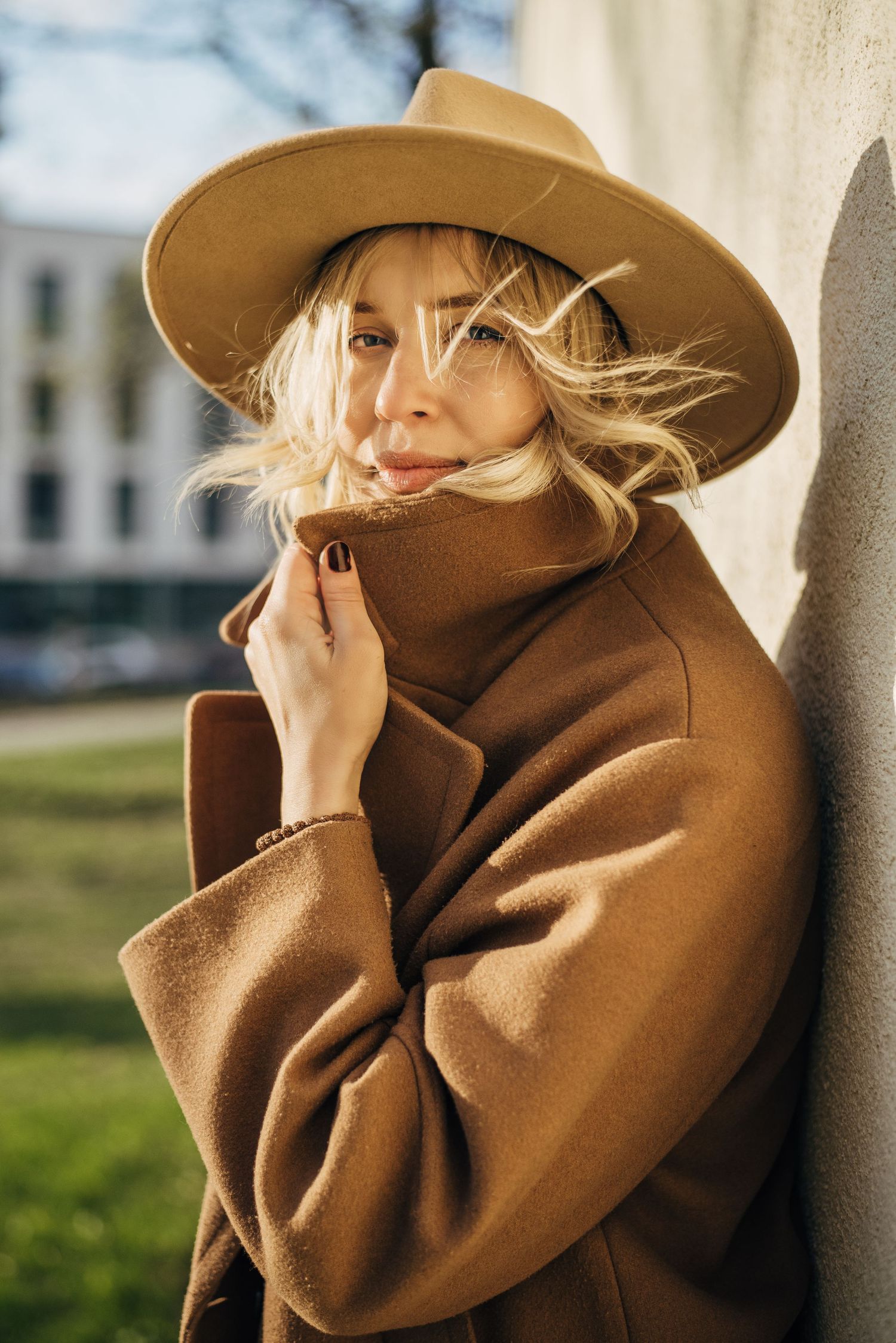 Artistic outdoor portrait series featuring a brown felt hat and camel coat combination.