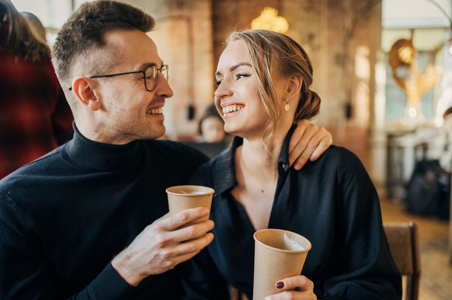 Cozy coffee date captured in warm lighting with intimate conversation and laughter.