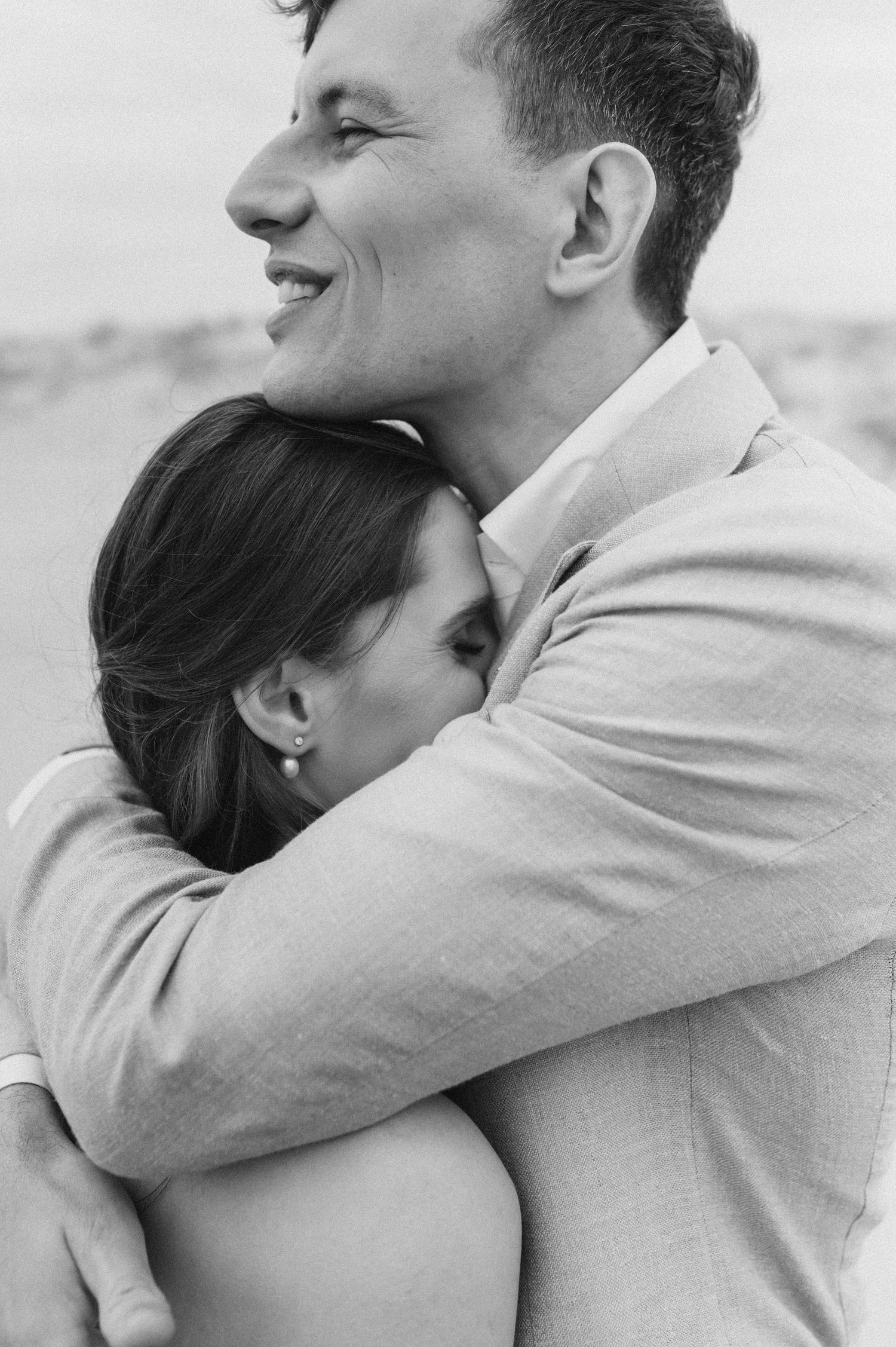 A series of black and white photos showing a couple embracing in a romantic moment outdoors.