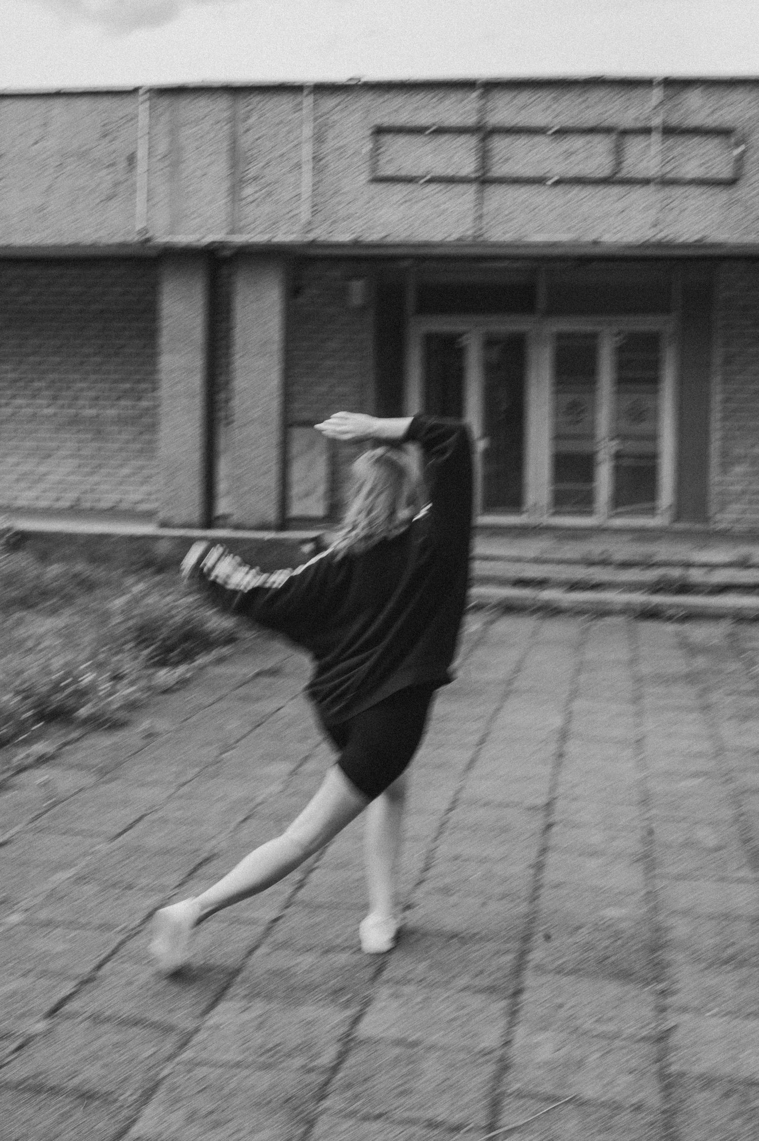 Black and white sequence of person dancing on urban pavement.