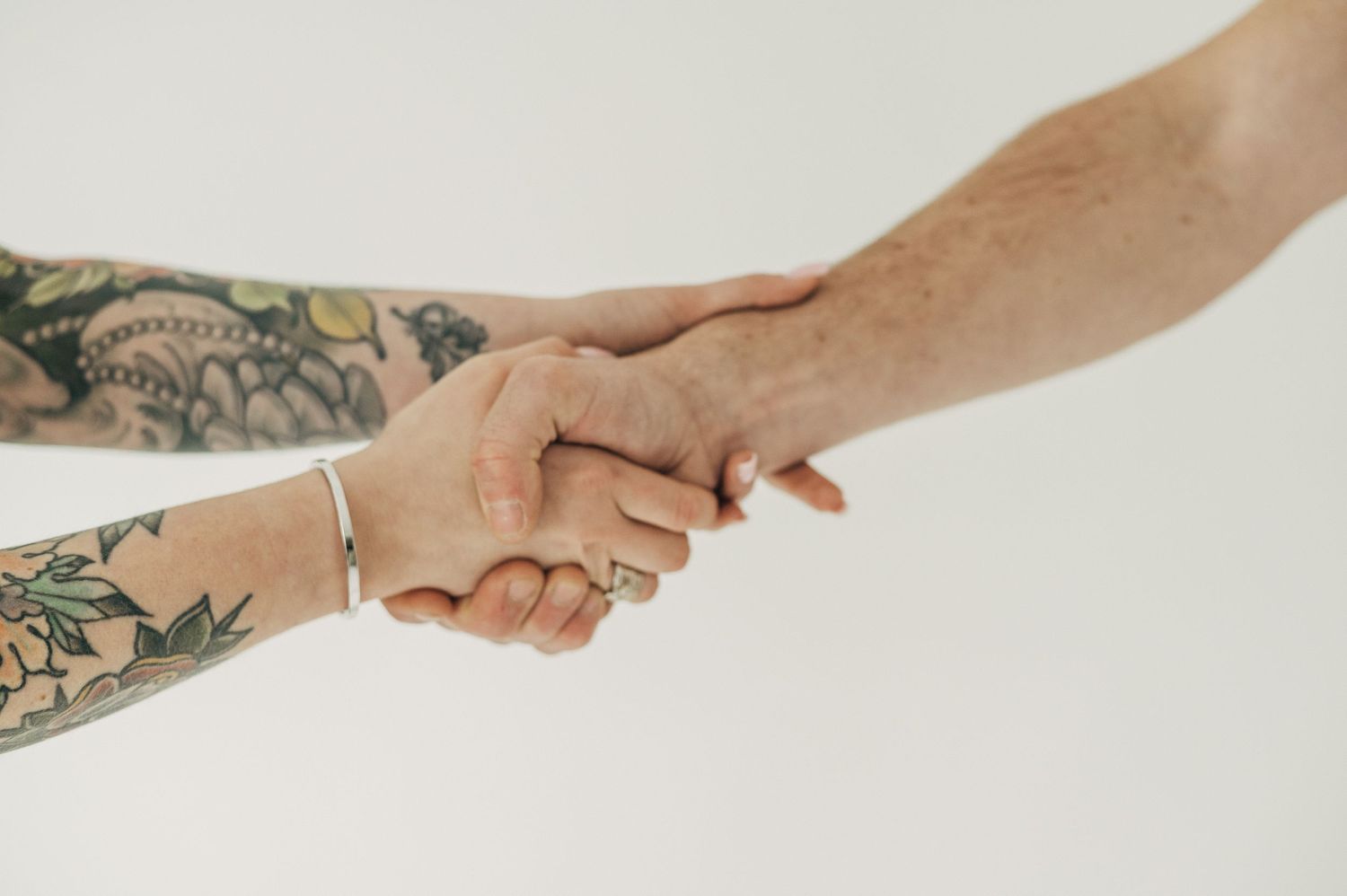 Close-up shots of tattooed hands reaching and connecting in various poses.