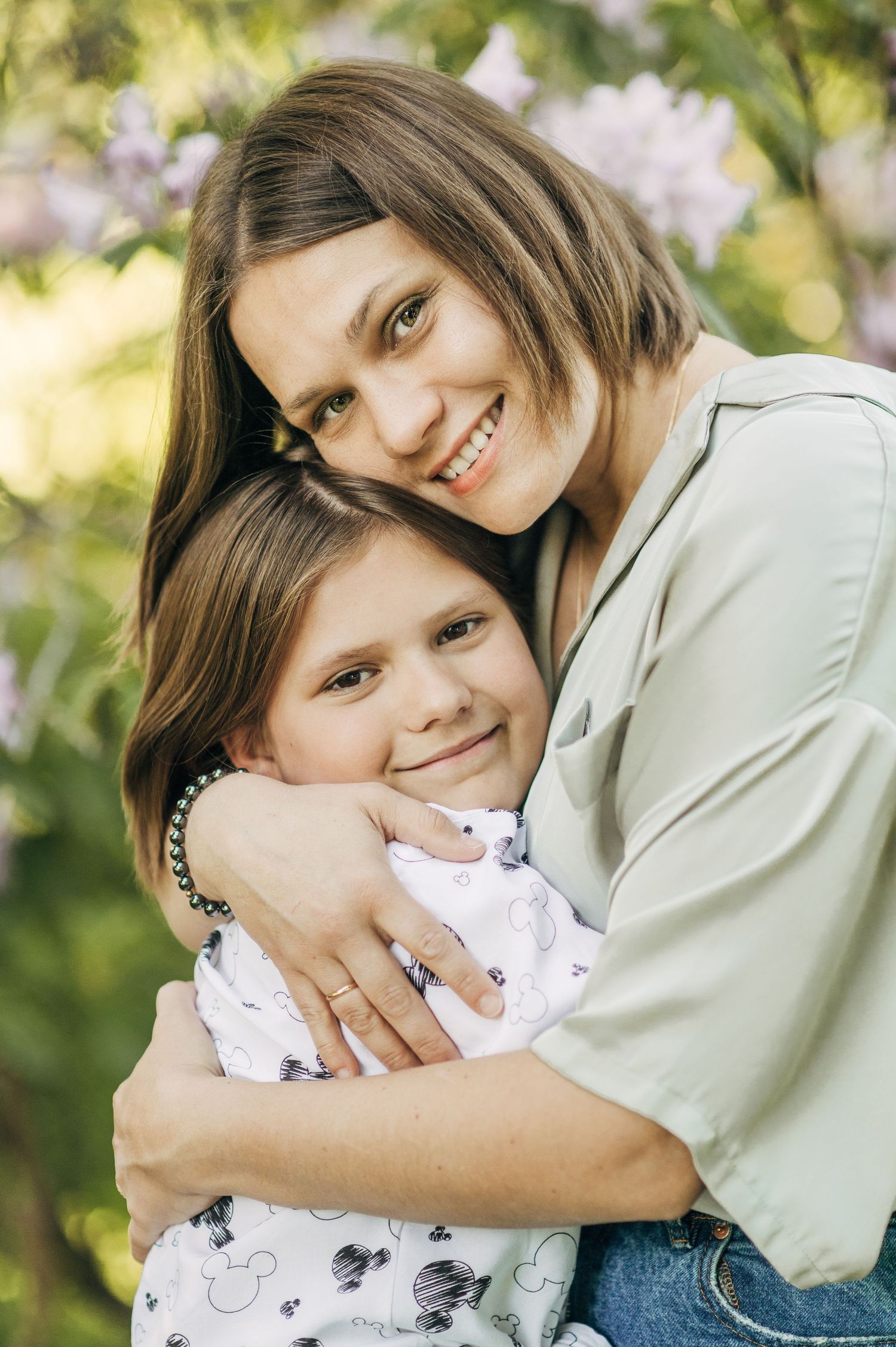 A tender moment captured as two people share an embrace outdoors in soft natural lighting.