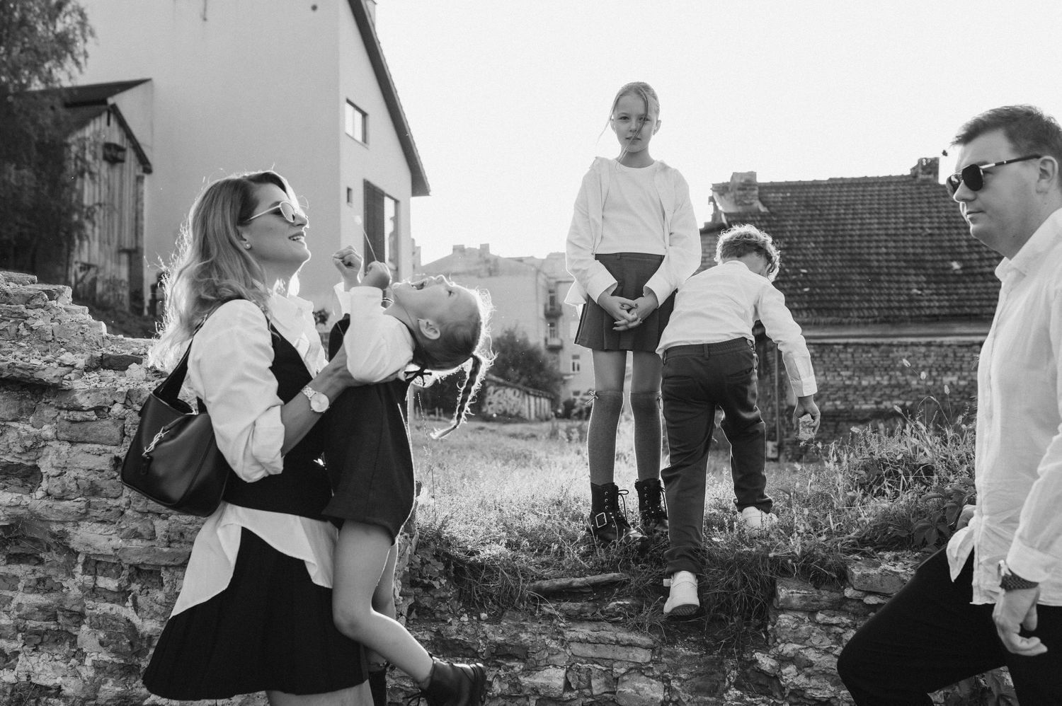 Children playing together and posing outdoors in black and white.