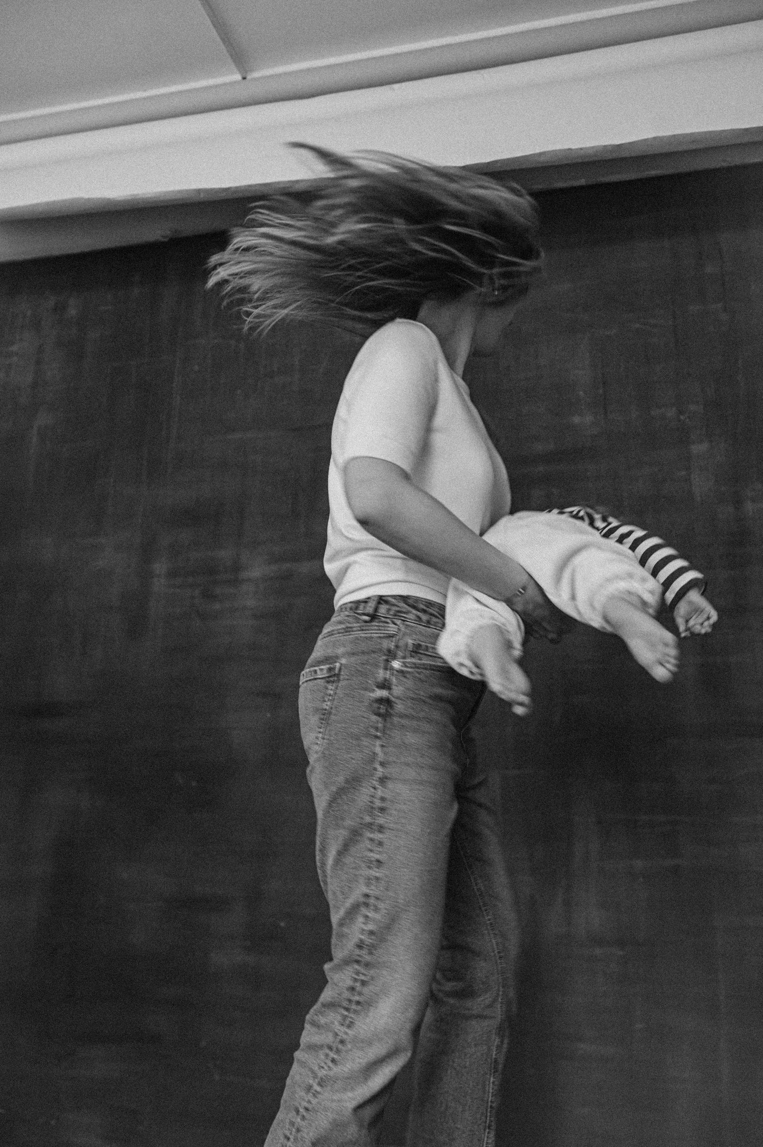 Black and white photo sequence of people lying on floor against dark wall wearing casual denim.