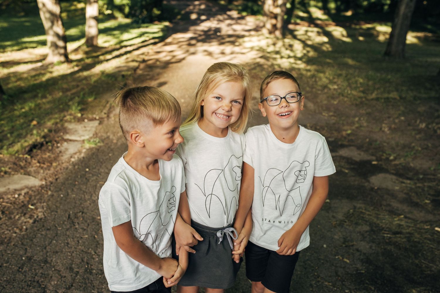 Candid outdoor photo sequence showing playful interaction between siblings in matching white shirts.