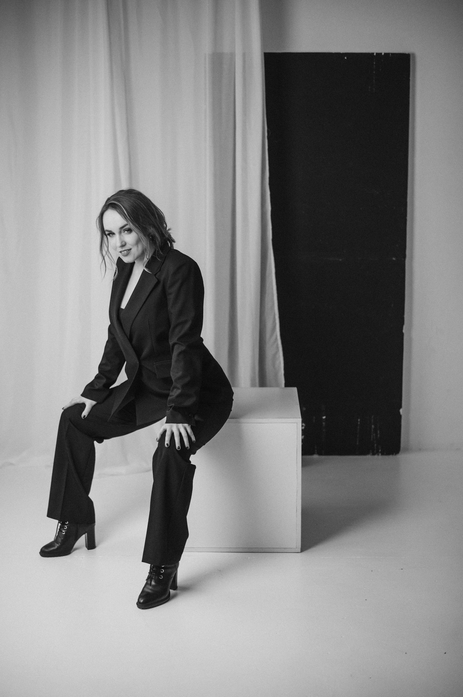 Artistic black and white fashion portraits showing poses against minimalist studio backdrop.