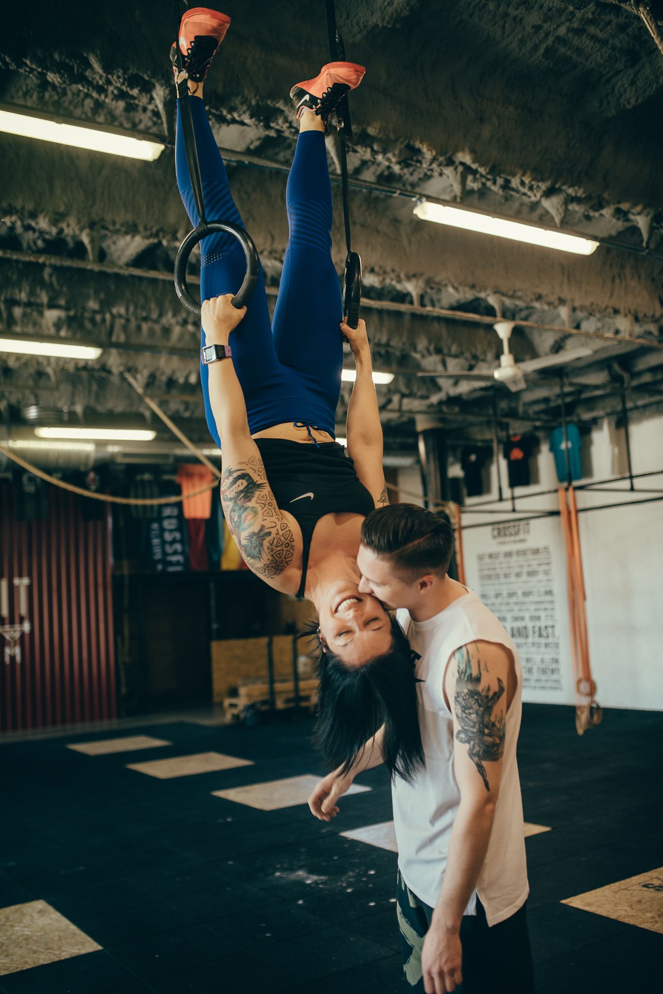 Athletes performing crossfit exercises with weights in an industrial gym setting.