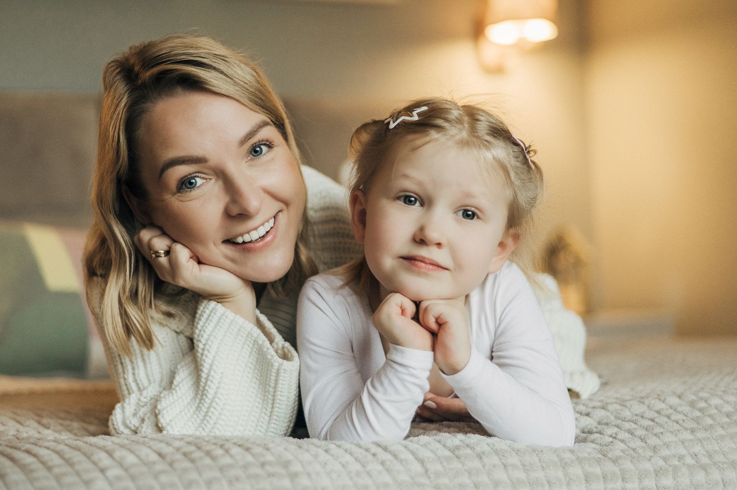 Family members sharing tender moments together while lying on a bed in natural lighting.