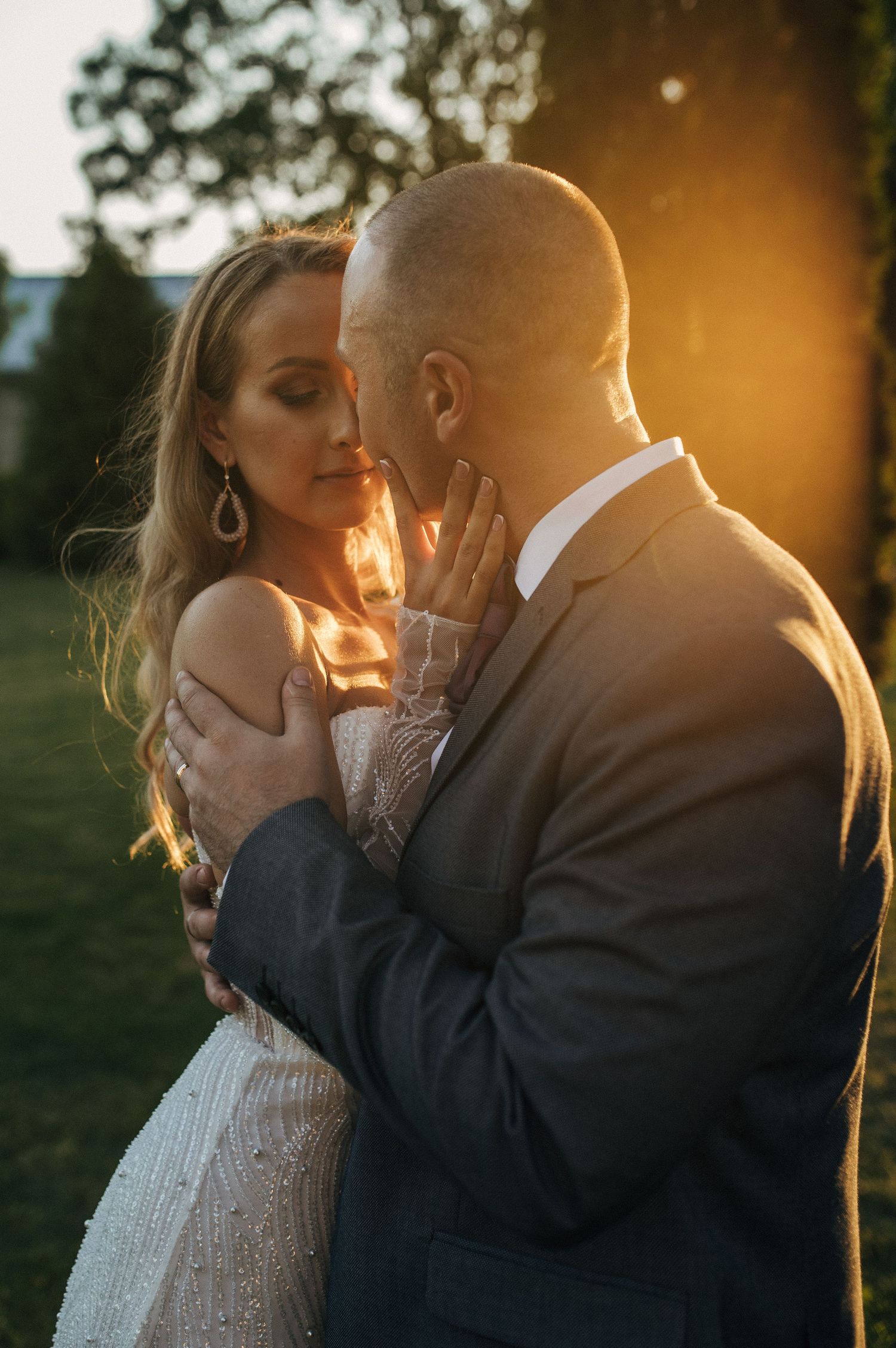Romantic sunset portraits of newlyweds embracing with golden light creating a dreamy atmosphere.