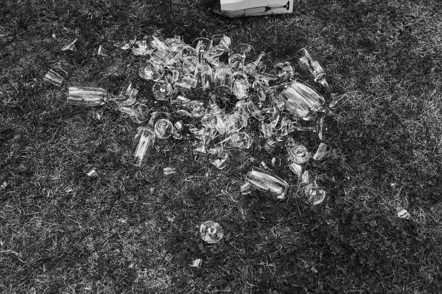 Decorative glass bottles and jars scattered on grass at an outdoor event.