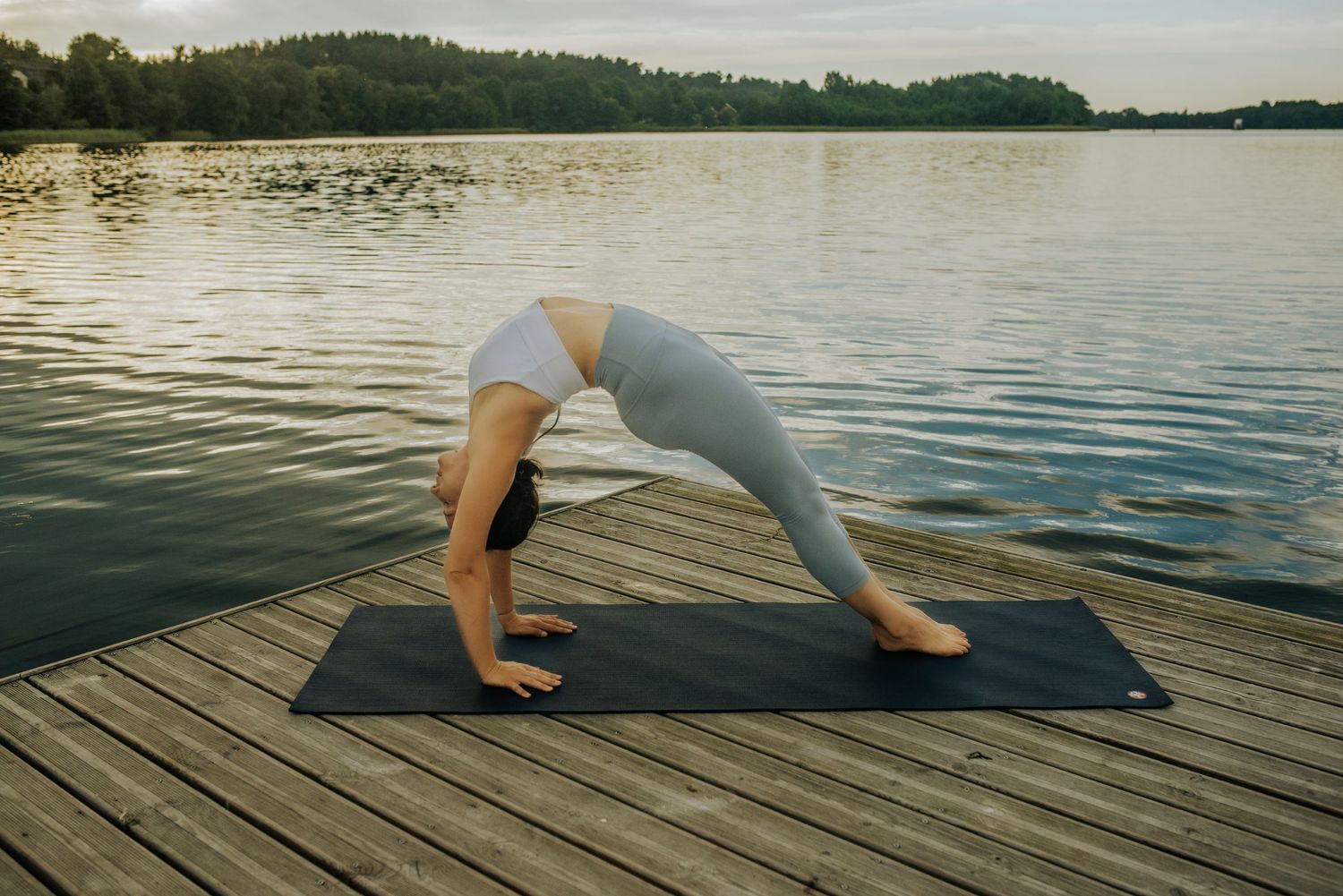 Yoga poses demonstrated on wooden dock with serene lake backdrop.