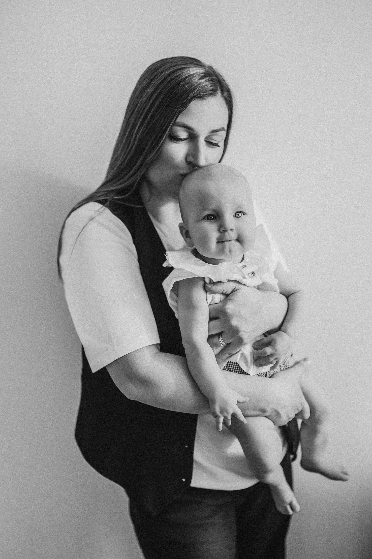 Black and white photos of intimate parent-child moment showing gentle interaction.